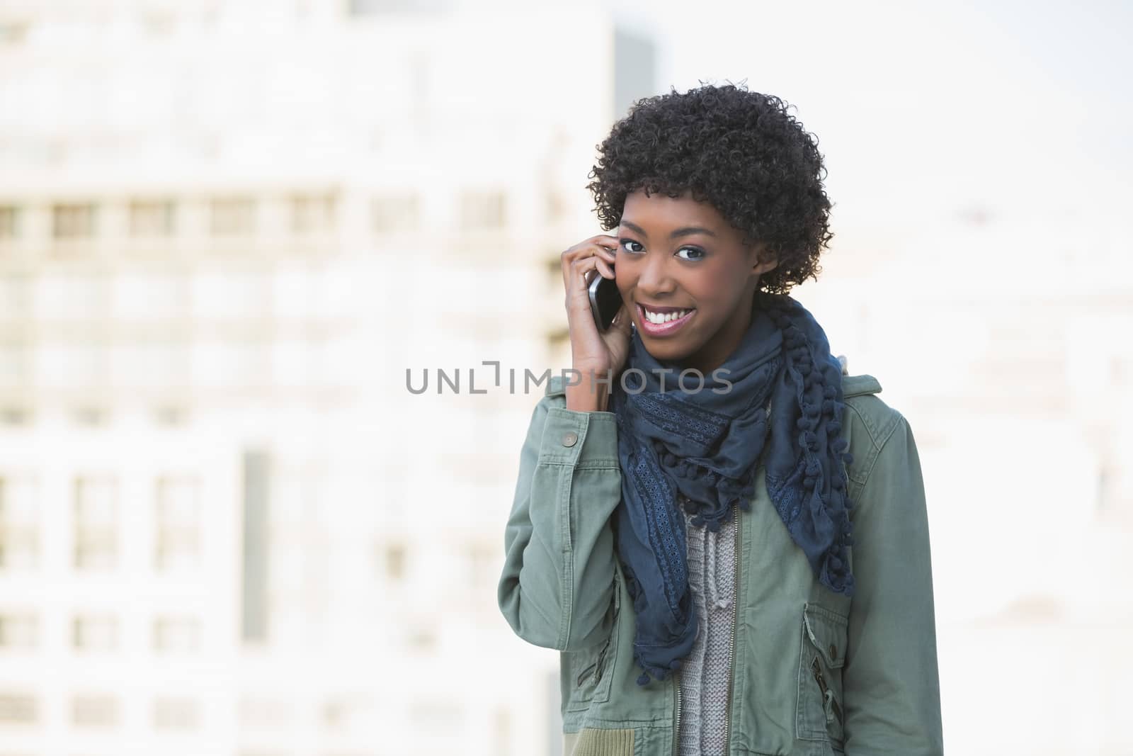 Cheerful afro model on the phone outdoors on a sunny day