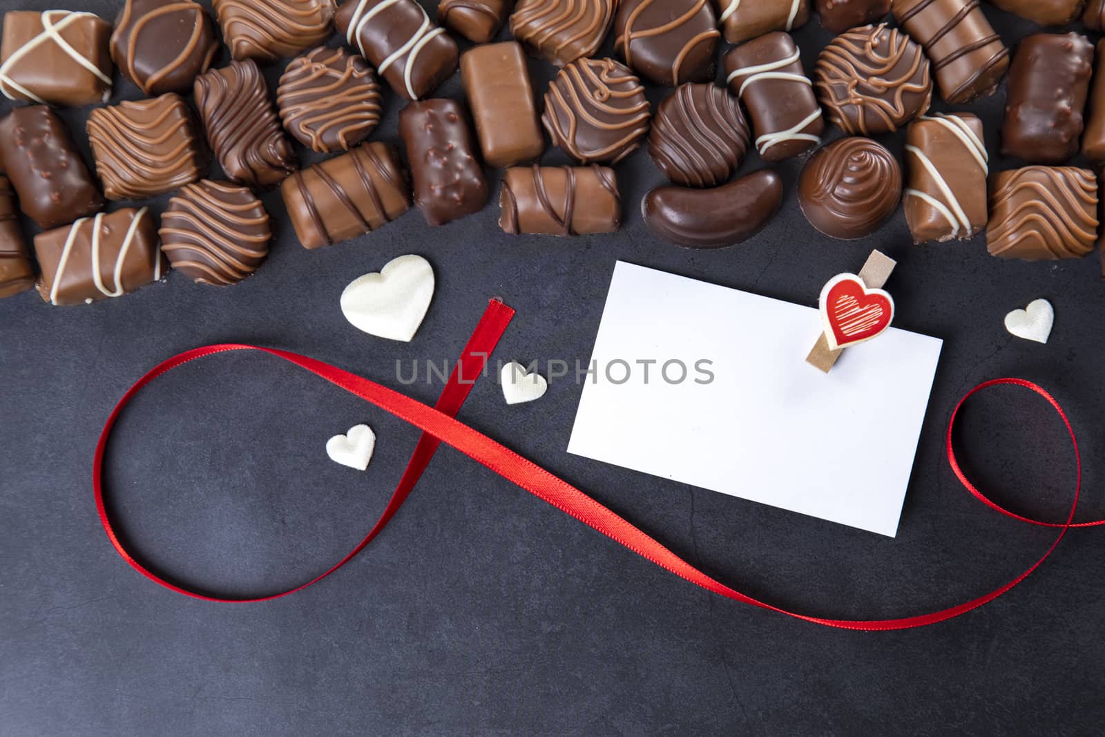 Chocolate pralines with card Valentines day on black background by manaemedia