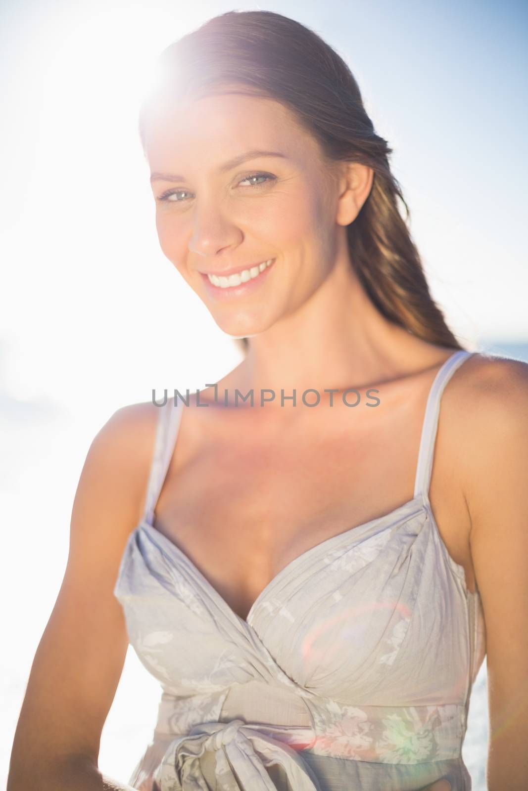Cheerful model in summer dress posing on the beach at dusk