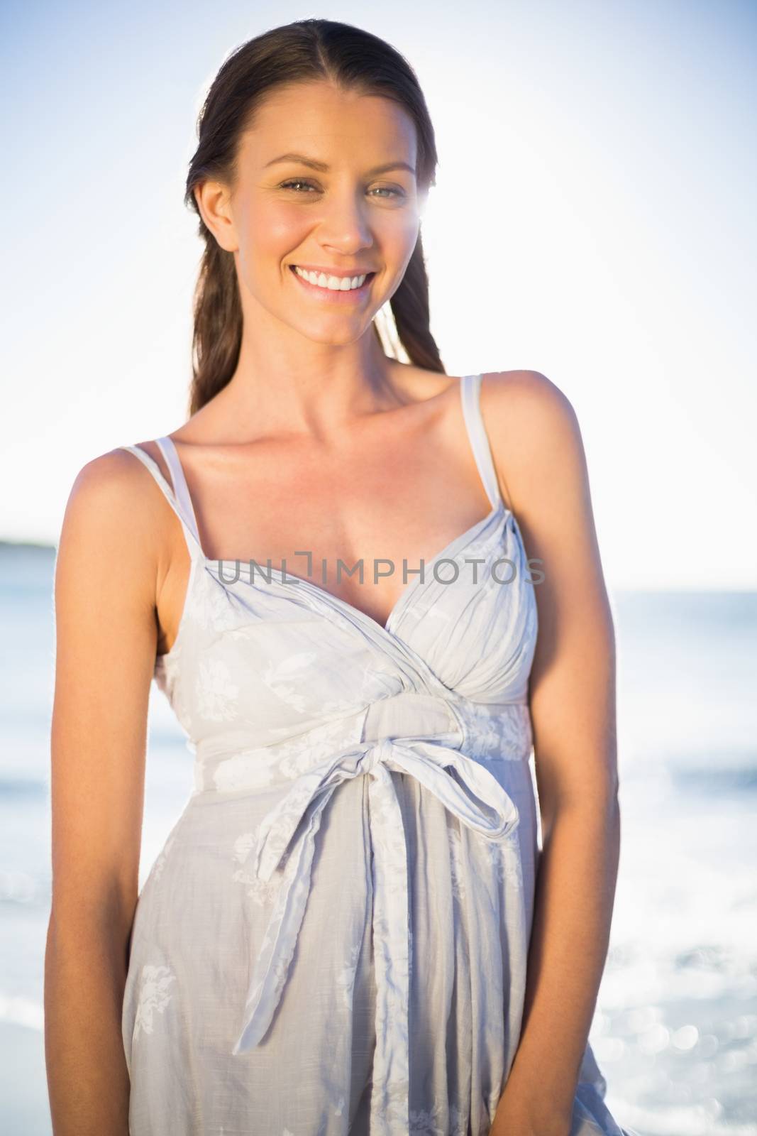 Happy gorgeous woman in summer dress posing on the beach at dusk