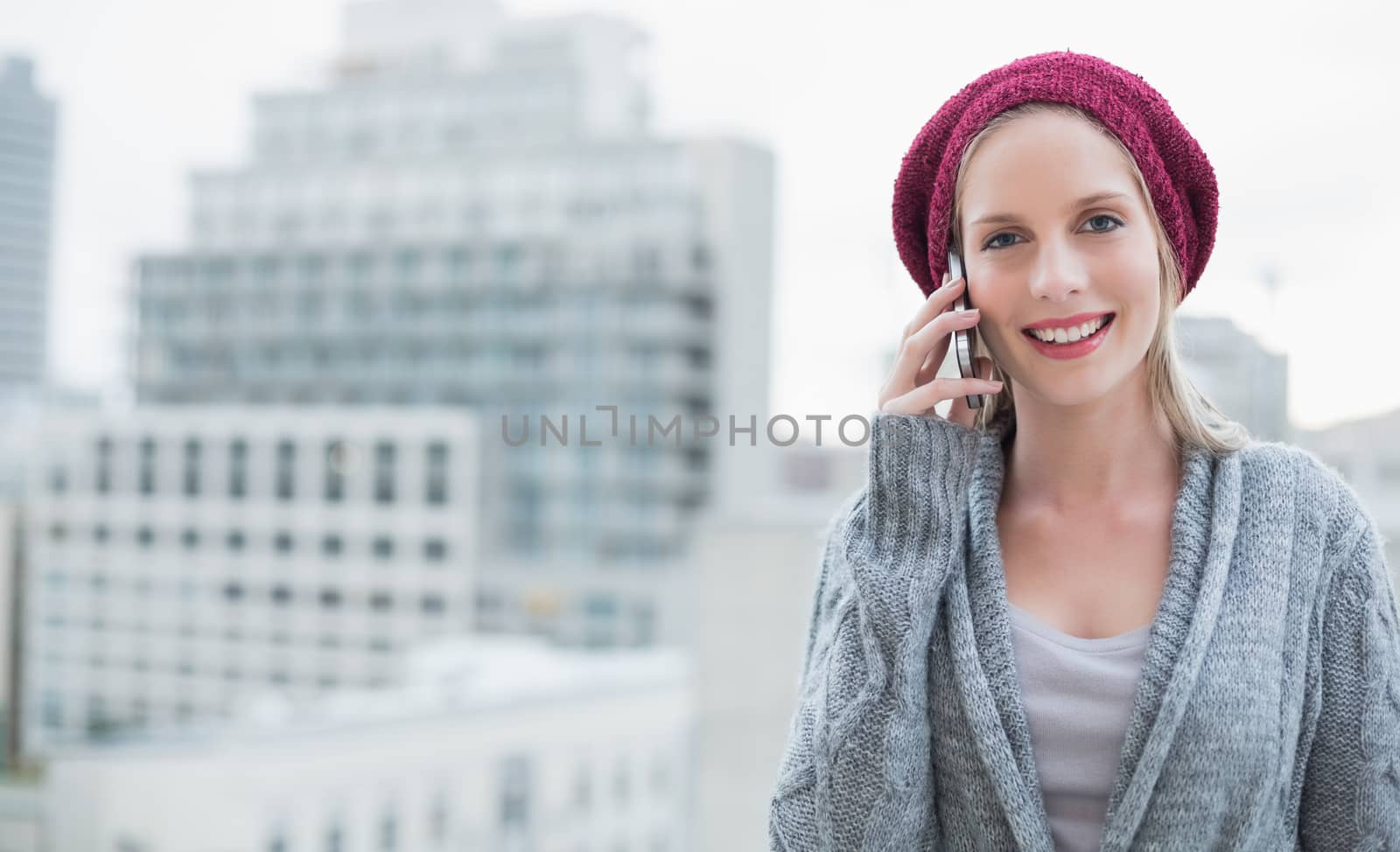 Cheerful pretty blonde on the phone outdoors by Wavebreakmedia