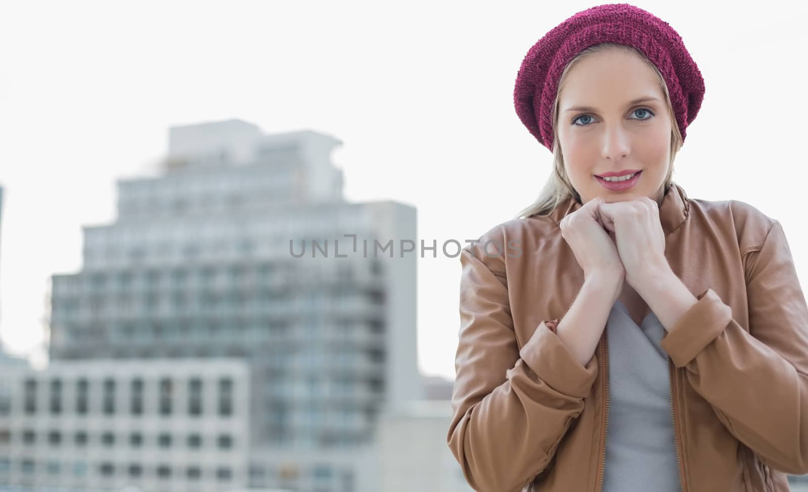 Shivering casual blonde posing outdoors on urban background