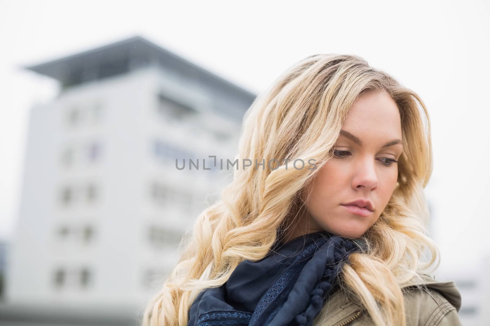 Young attractive blonde posing outdoors on urban background