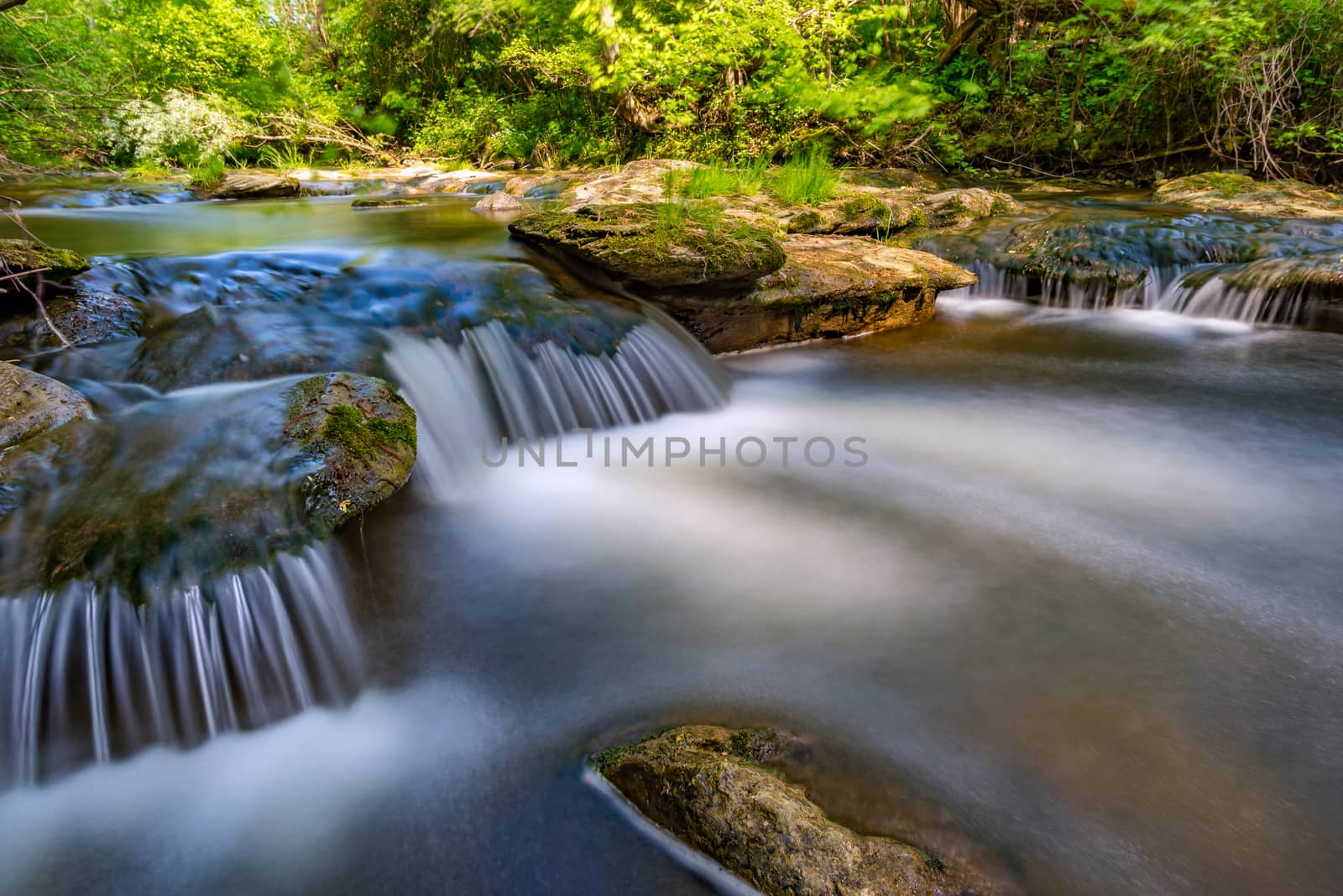 At the Felsenbad, a natural water pool with small waterfalls at lake Schussen in Upper Swabia