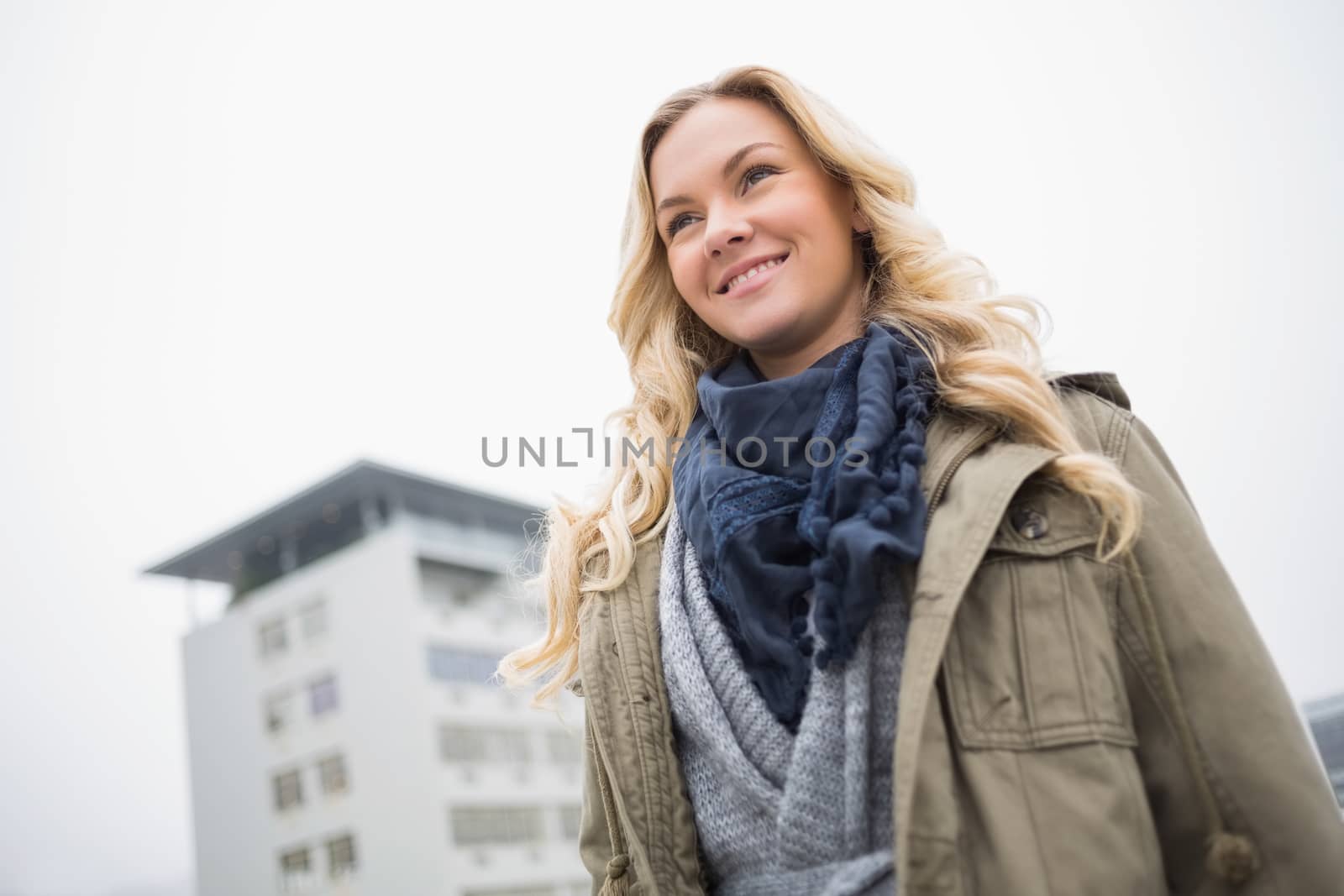 Cheerful attractive blonde posing outdoors on urban background