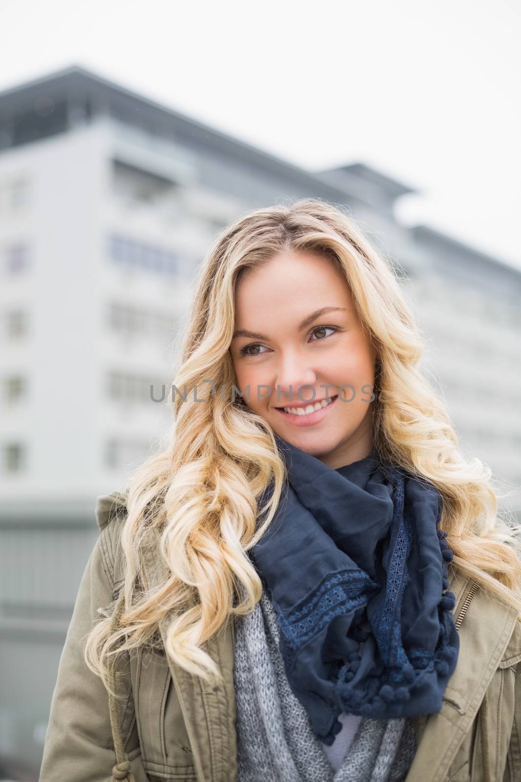 Cheerful casual blonde posing outdoors on urban background