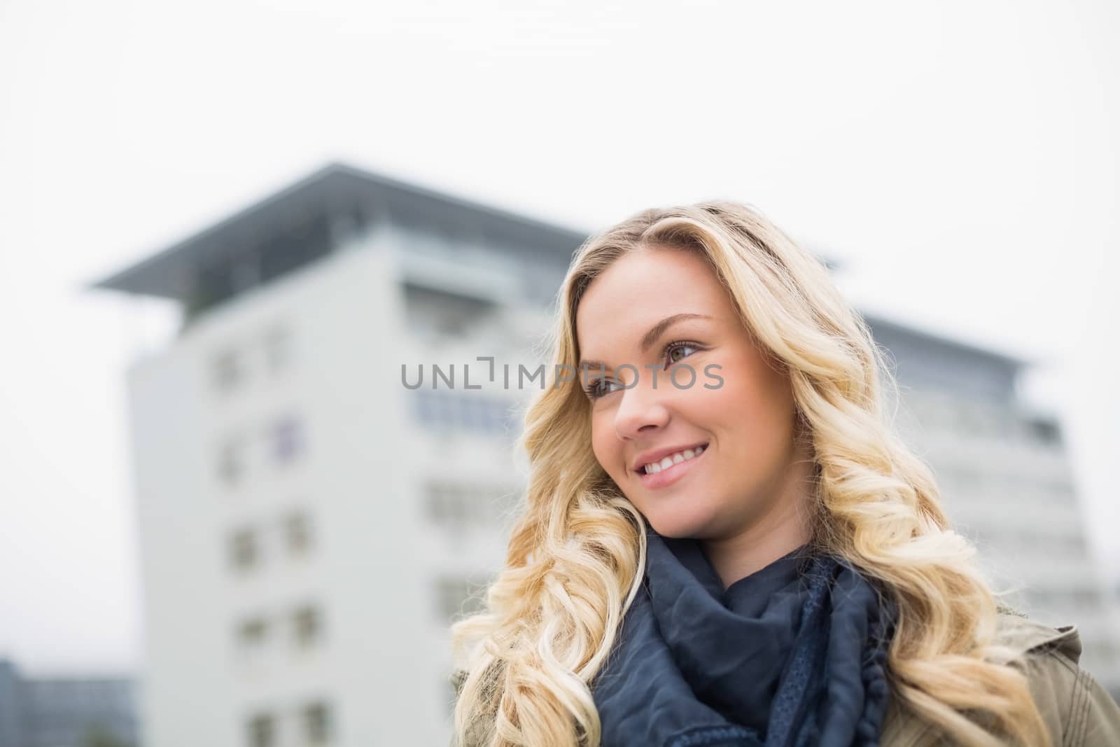 Cheerful trendy blonde posing outdoors on urban background