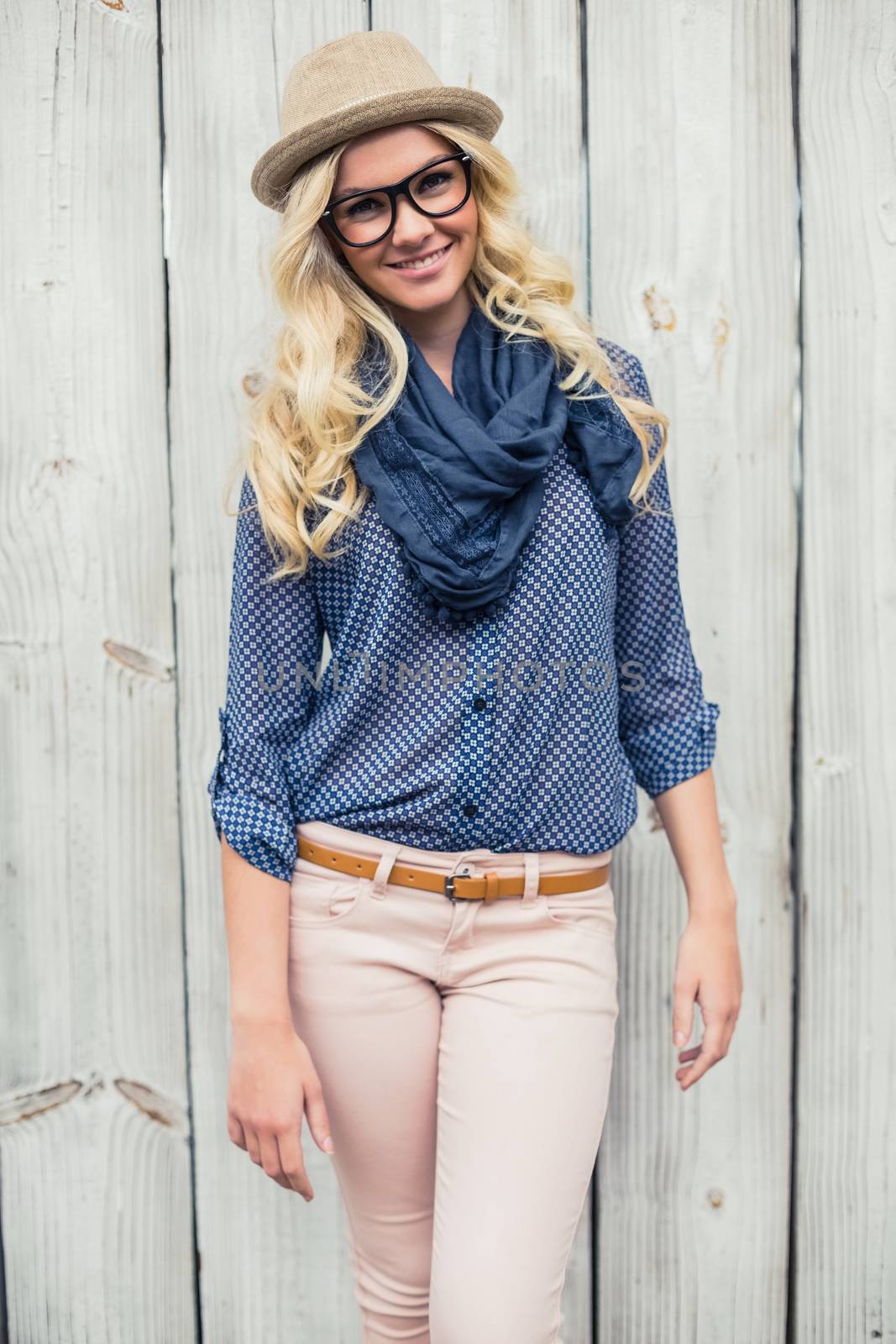 Cheerful fashionable blonde posing outdoors on wooden background