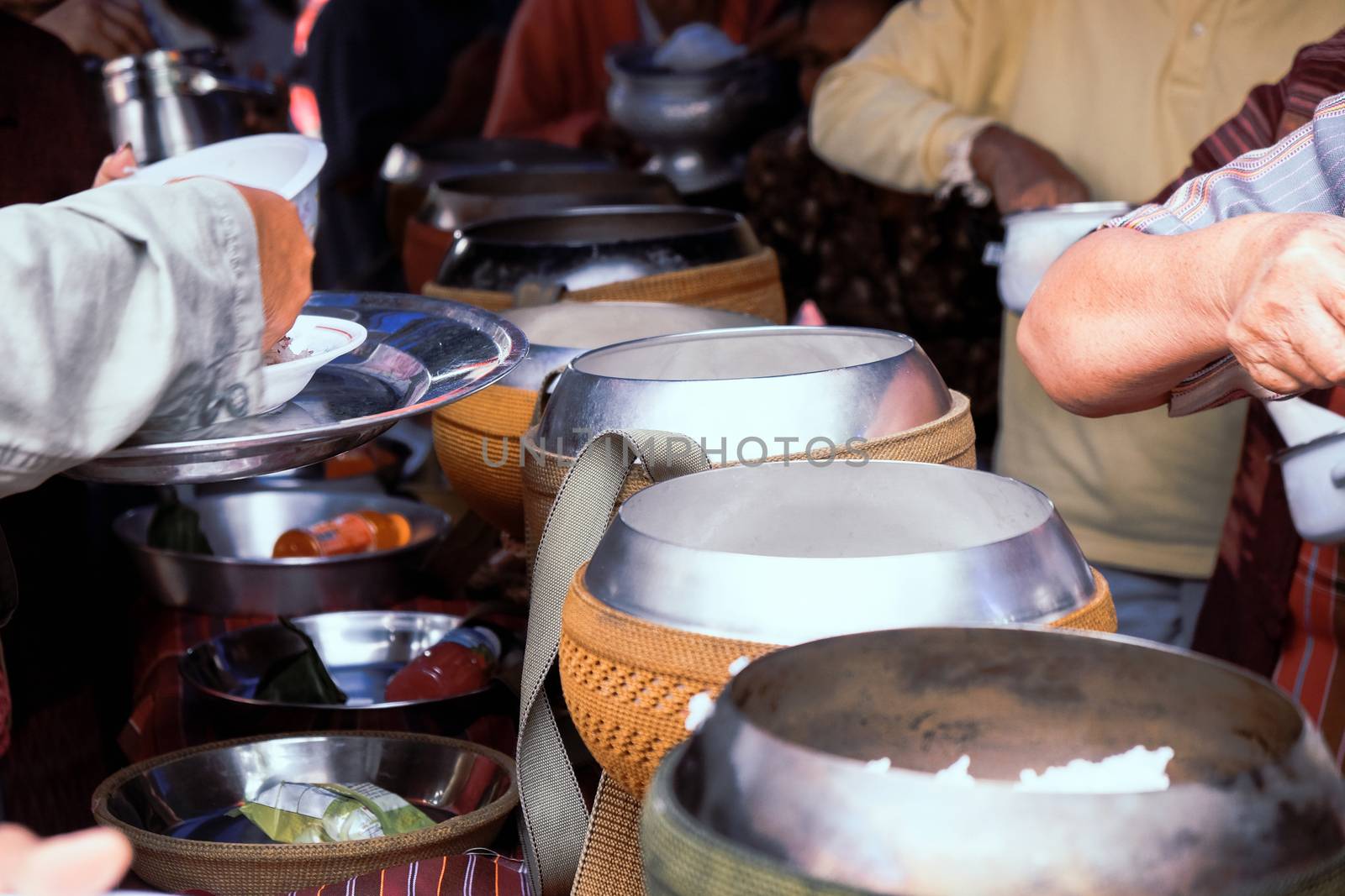 Give alms, to offer food to the monks