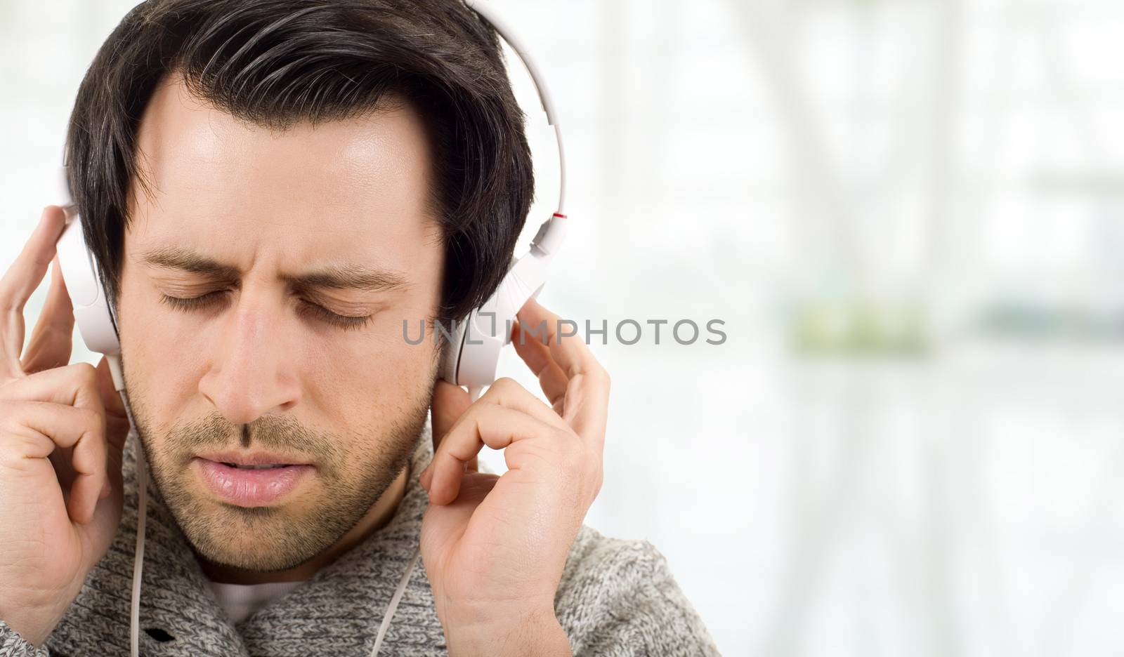 Happy young man with headphones, listening to music with eyes closed