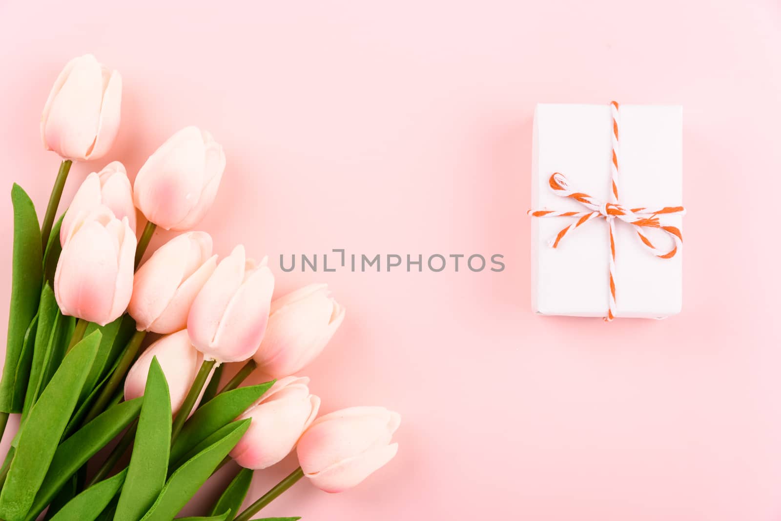 Happy Women's Day, Mother's Day concept. top view flat lay gift box and Tulip flower on pink background, copy space for your text