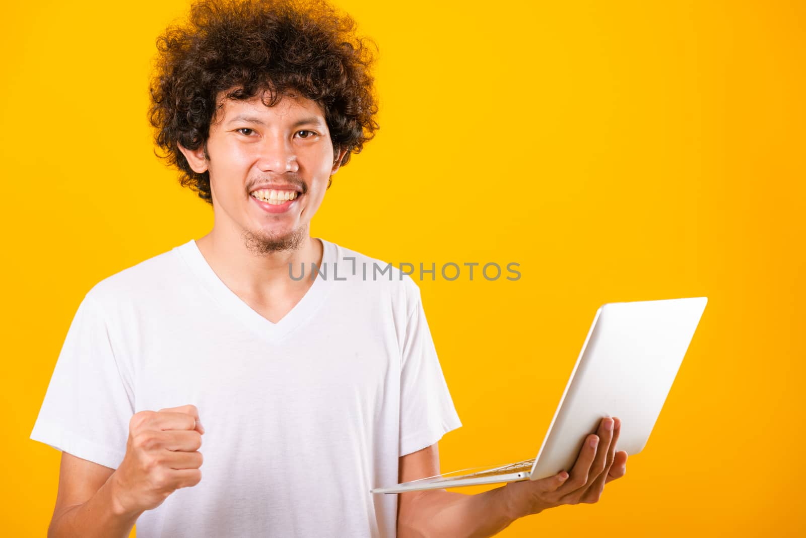Asian handsome man with curly hair using laptop computer isolate by Sorapop