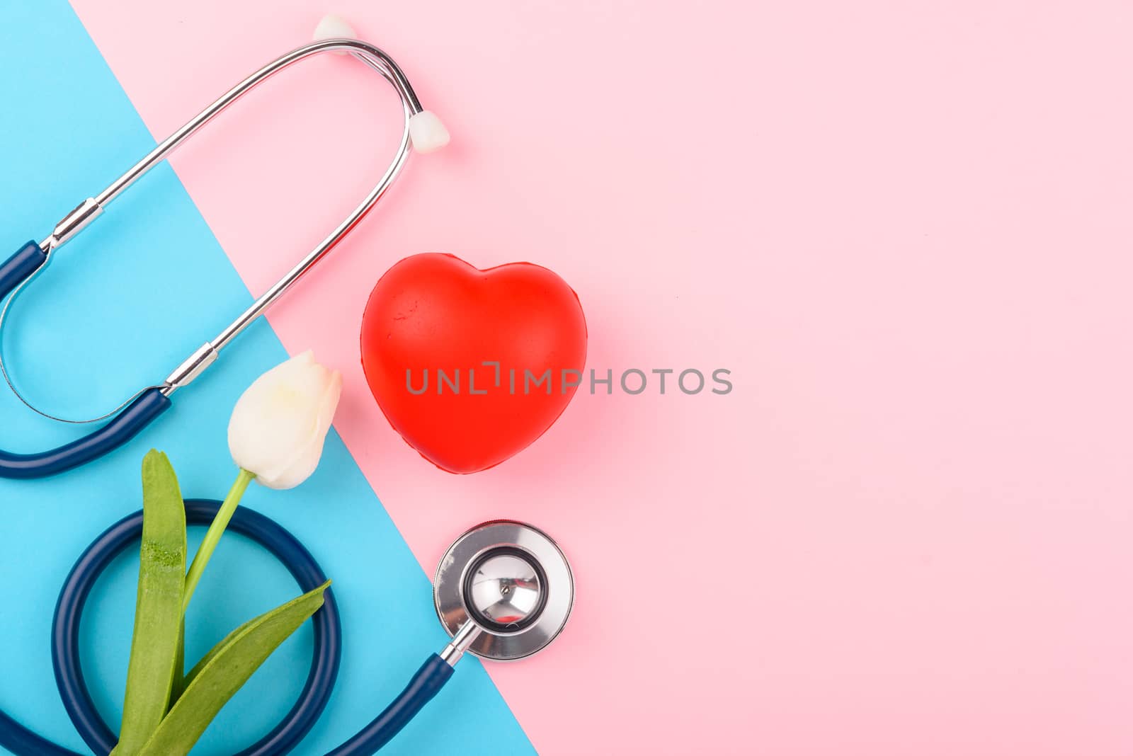Doctor's Day concept, flat lay top view, stethoscope with red heart on pink blue background, diagnosis of heart disease with copy space for text