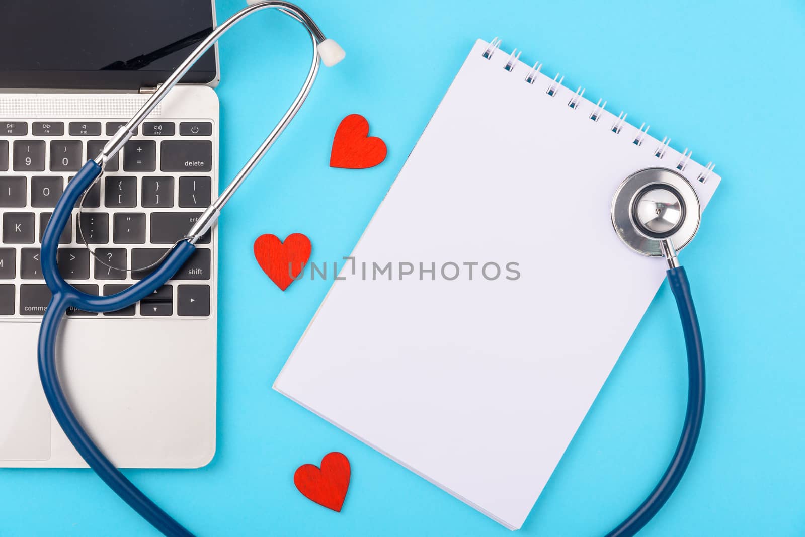 Doctor's Day concept, flat lay top view, stethoscope with peper note diagnosis of heart disease on blue background with copy space for text