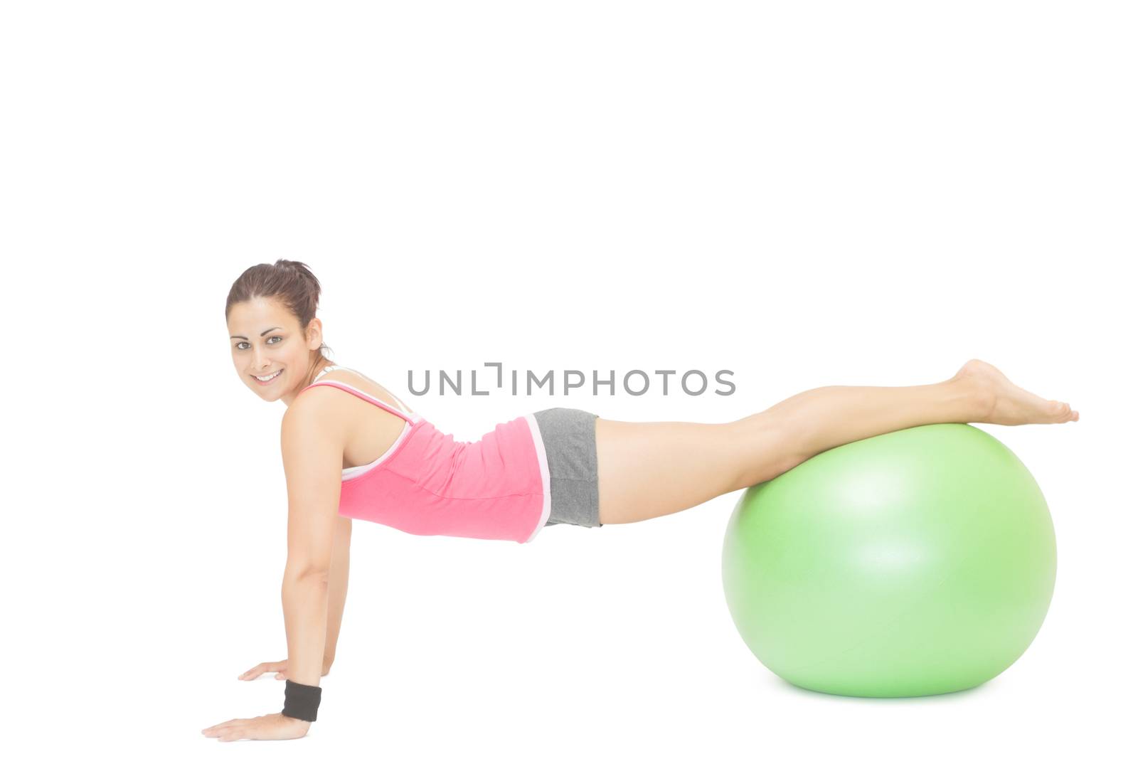 Smiling sporty brunette doing exercise with exercise ball by Wavebreakmedia