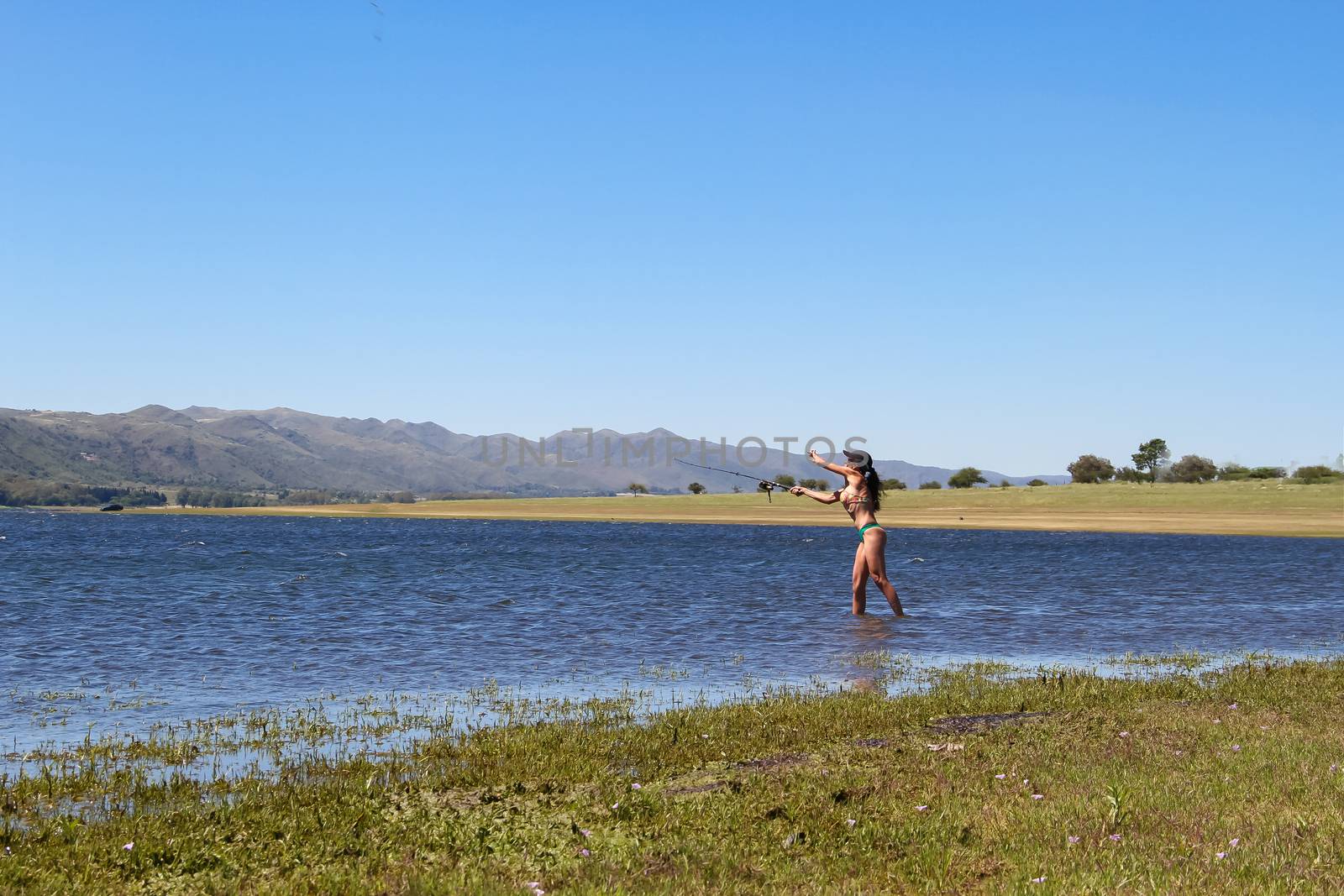 beautiful young woman fishing the mountain lake