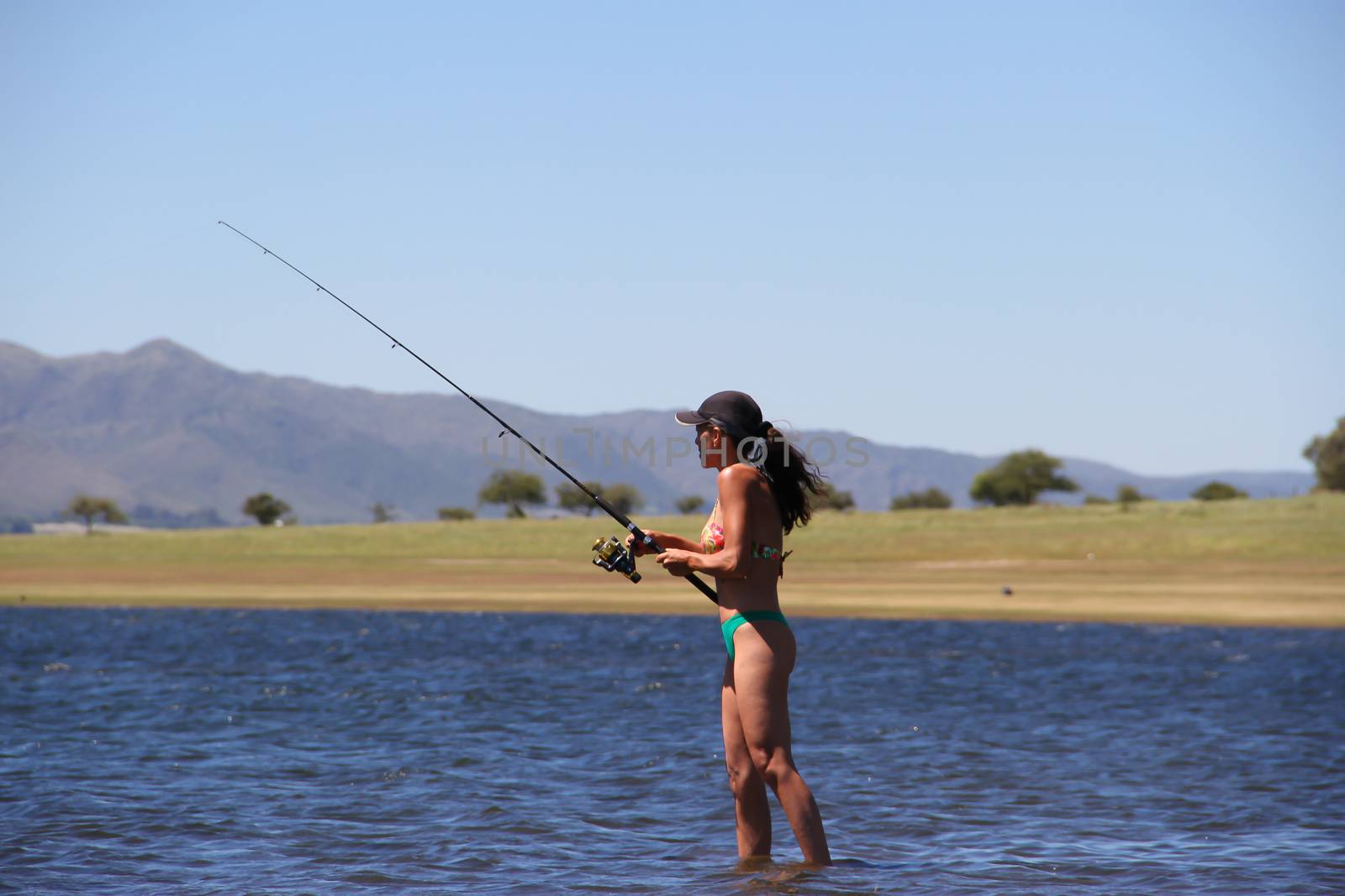 beautiful young woman fishing the mountain lake