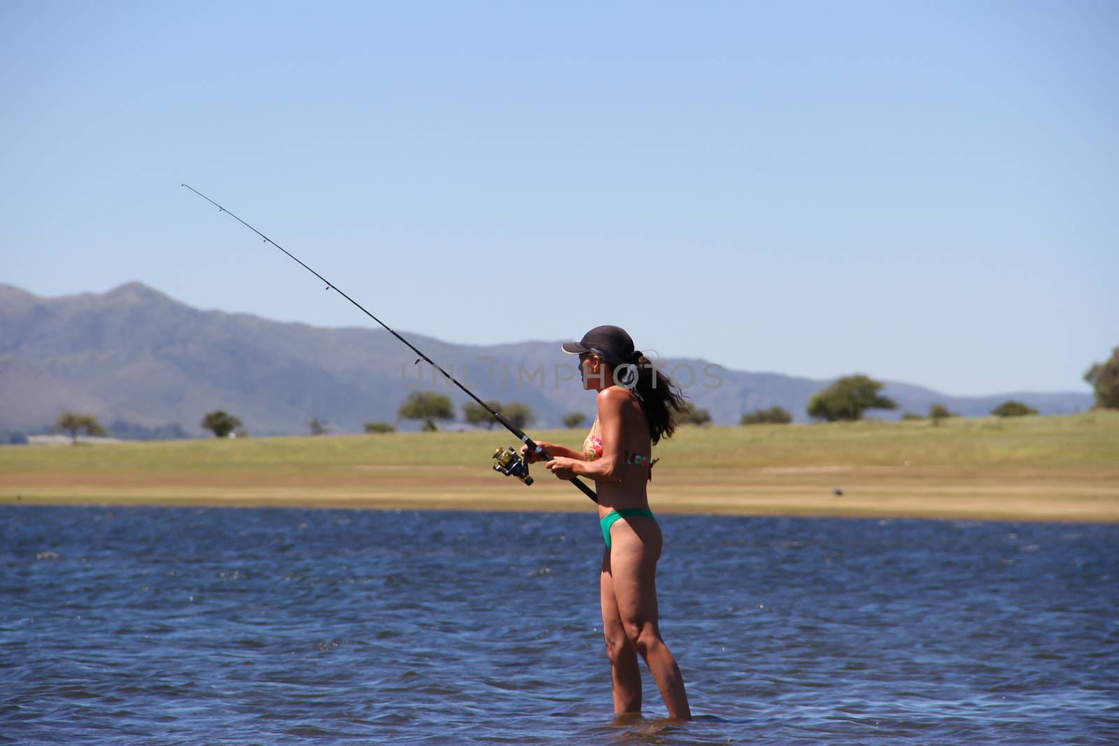 beautiful young woman fishing the mountain lake