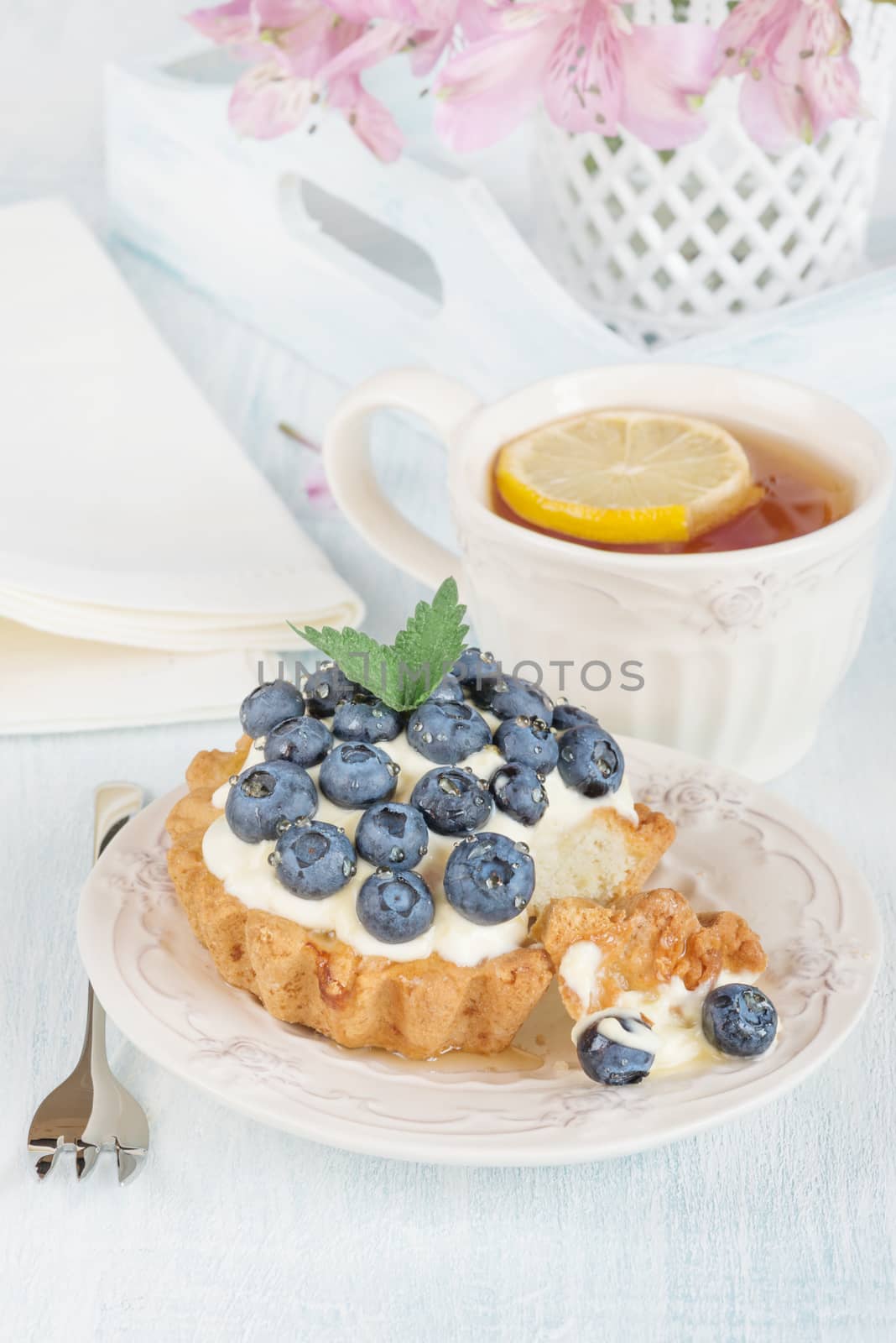 Continental breakfast with cheesecake, fresh berries and tea with lemon