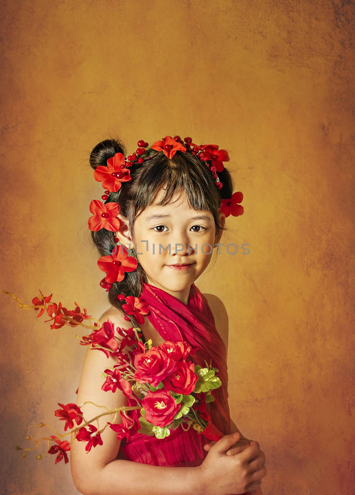 Cute asian little girl with wreath of flowers on her head