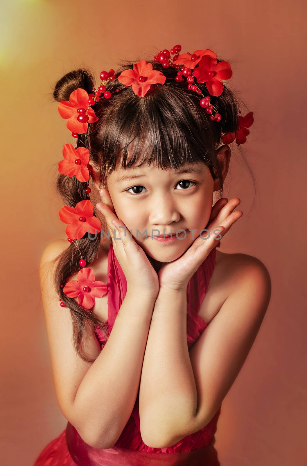 Cute asian little girl with wreath of flowers on her head