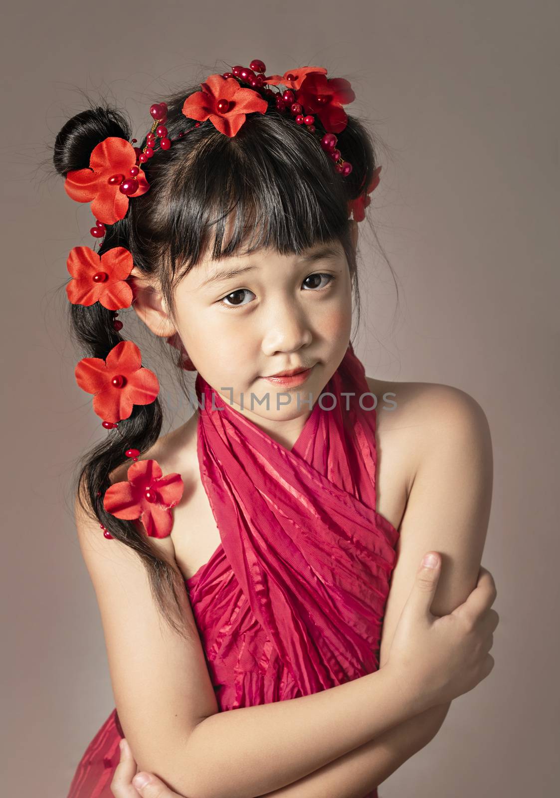 Cute asian little girl with wreath of flowers on her head