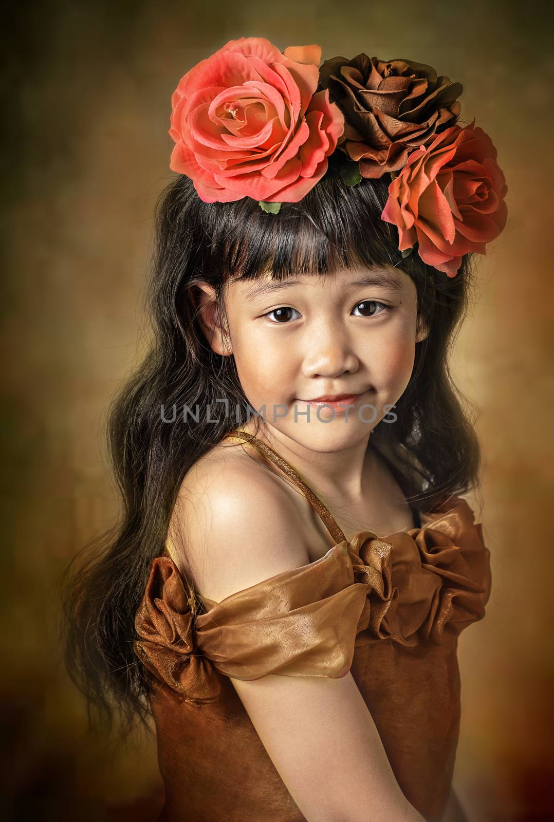 Cute asian little girl with wreath of flowers on her head