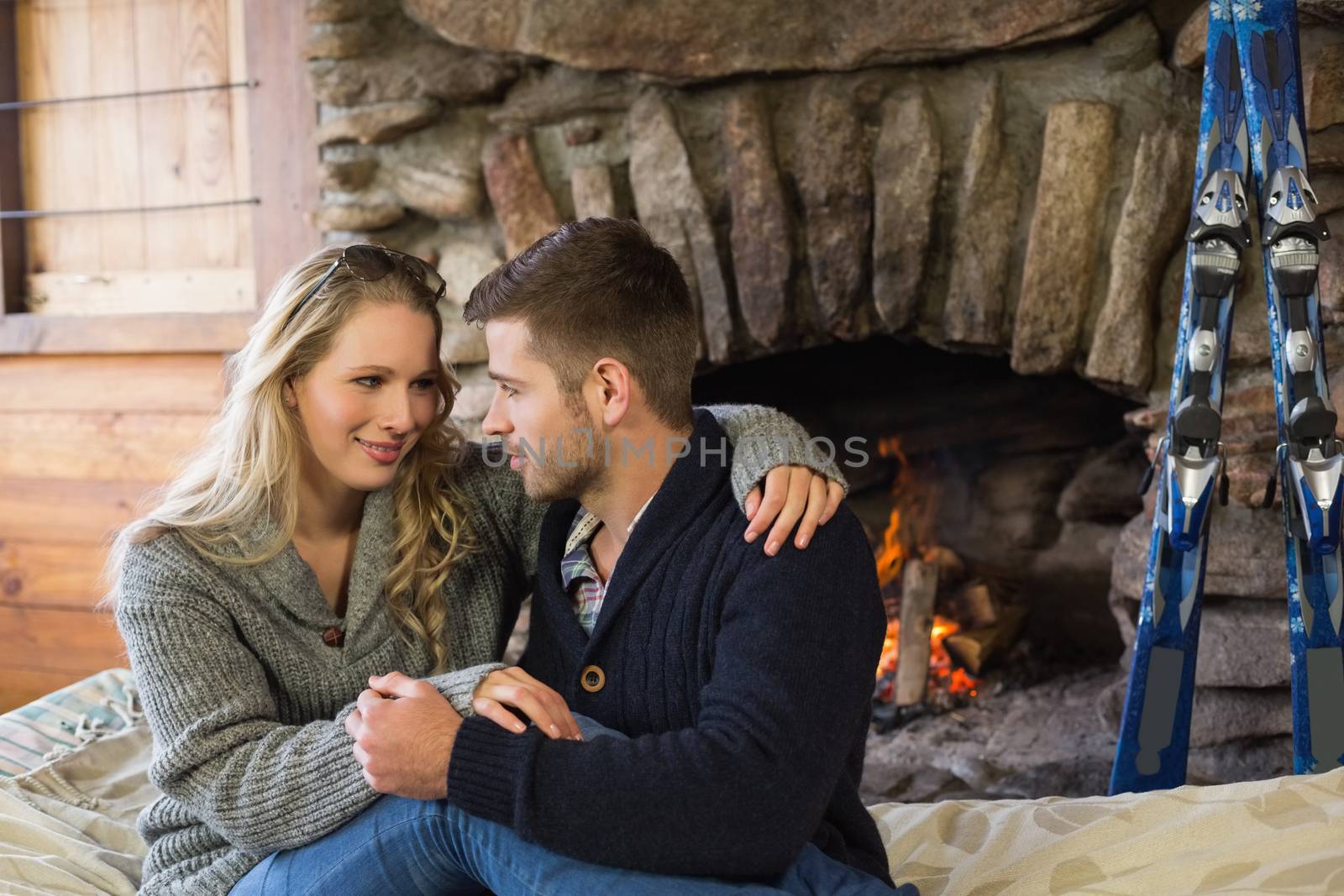 Romantic couple in front of lit fireplace by Wavebreakmedia