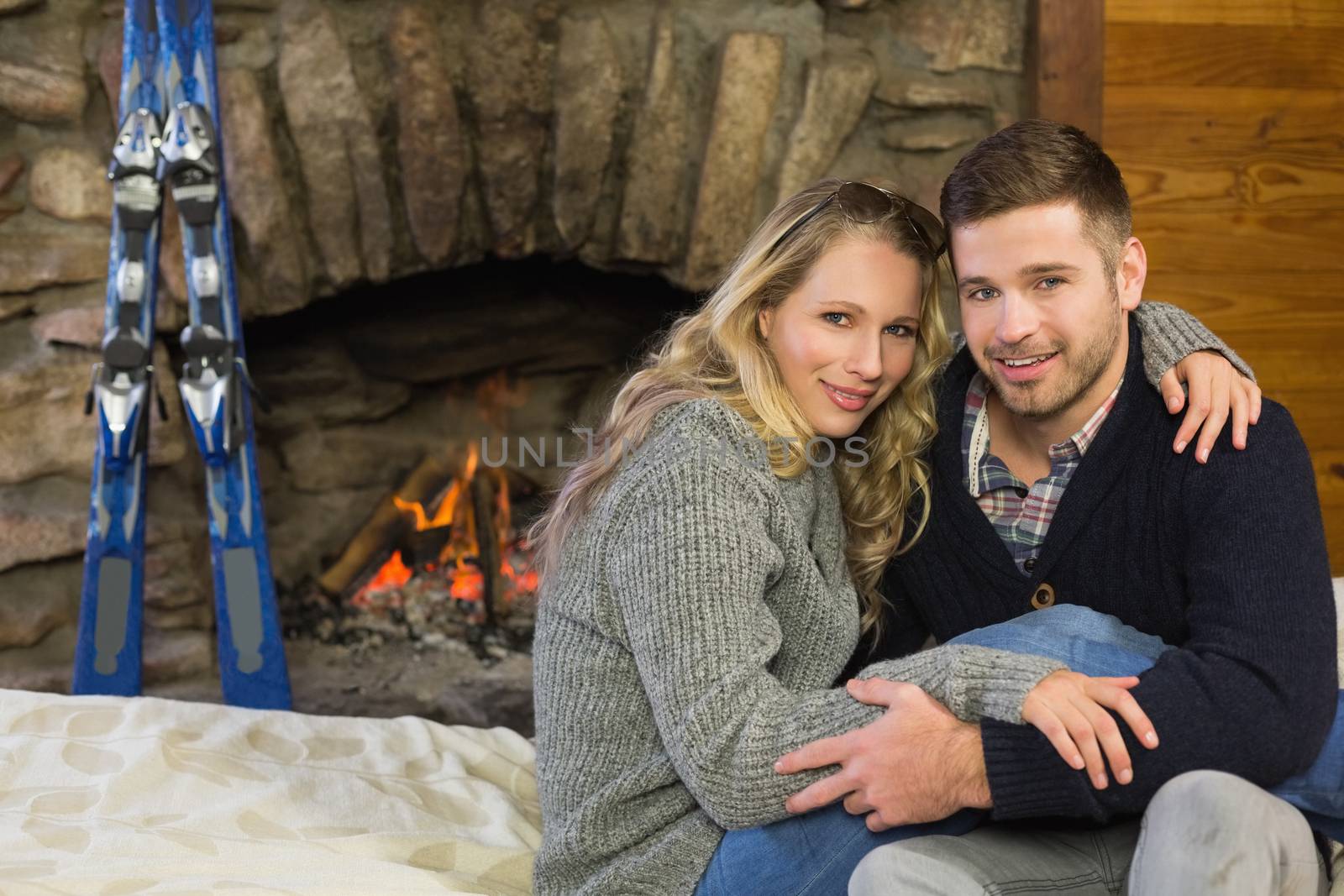 Portrait of a romantic couple in front of lit fireplace by Wavebreakmedia