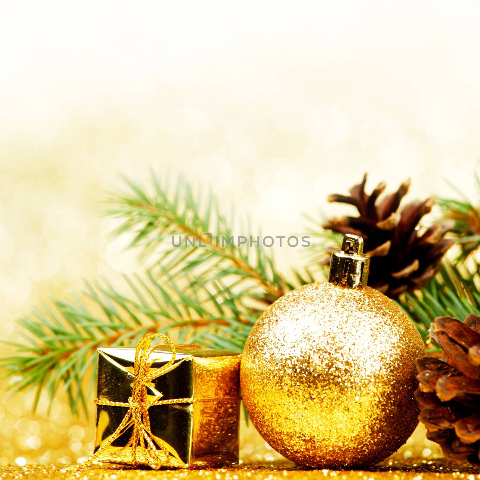 Christmas card with fir tree branch and decoration on golden glitter background