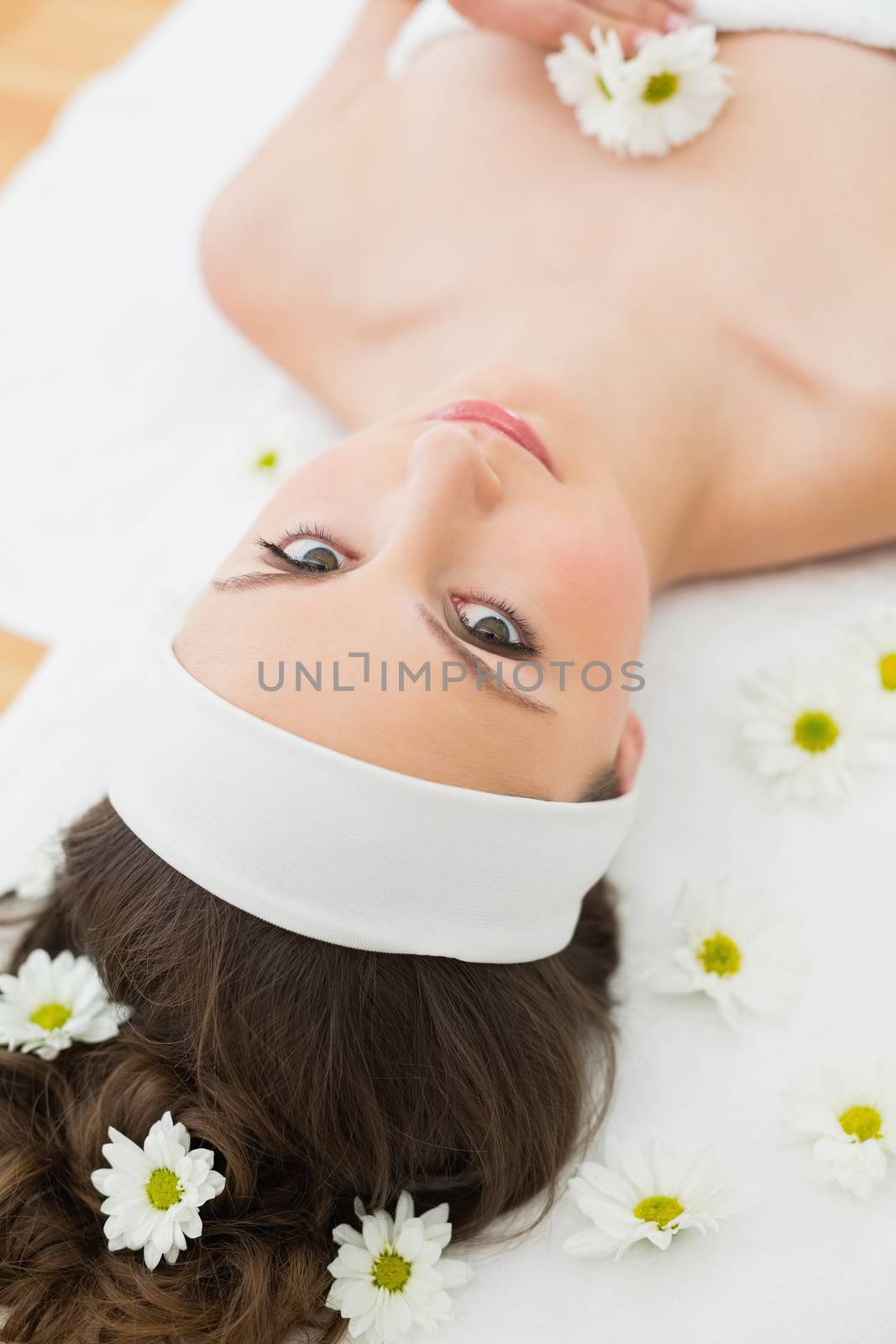 Overhead portrait of a young beautiful woman lying on massage table in beauty salon