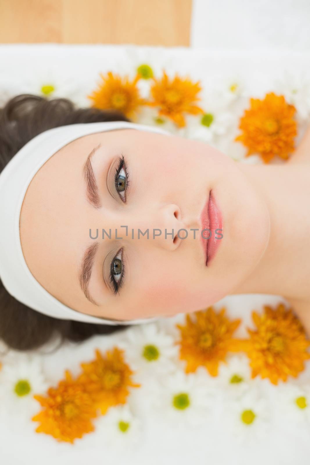 Overhead portrait of a beautiful young woman with flowers in beauty salon