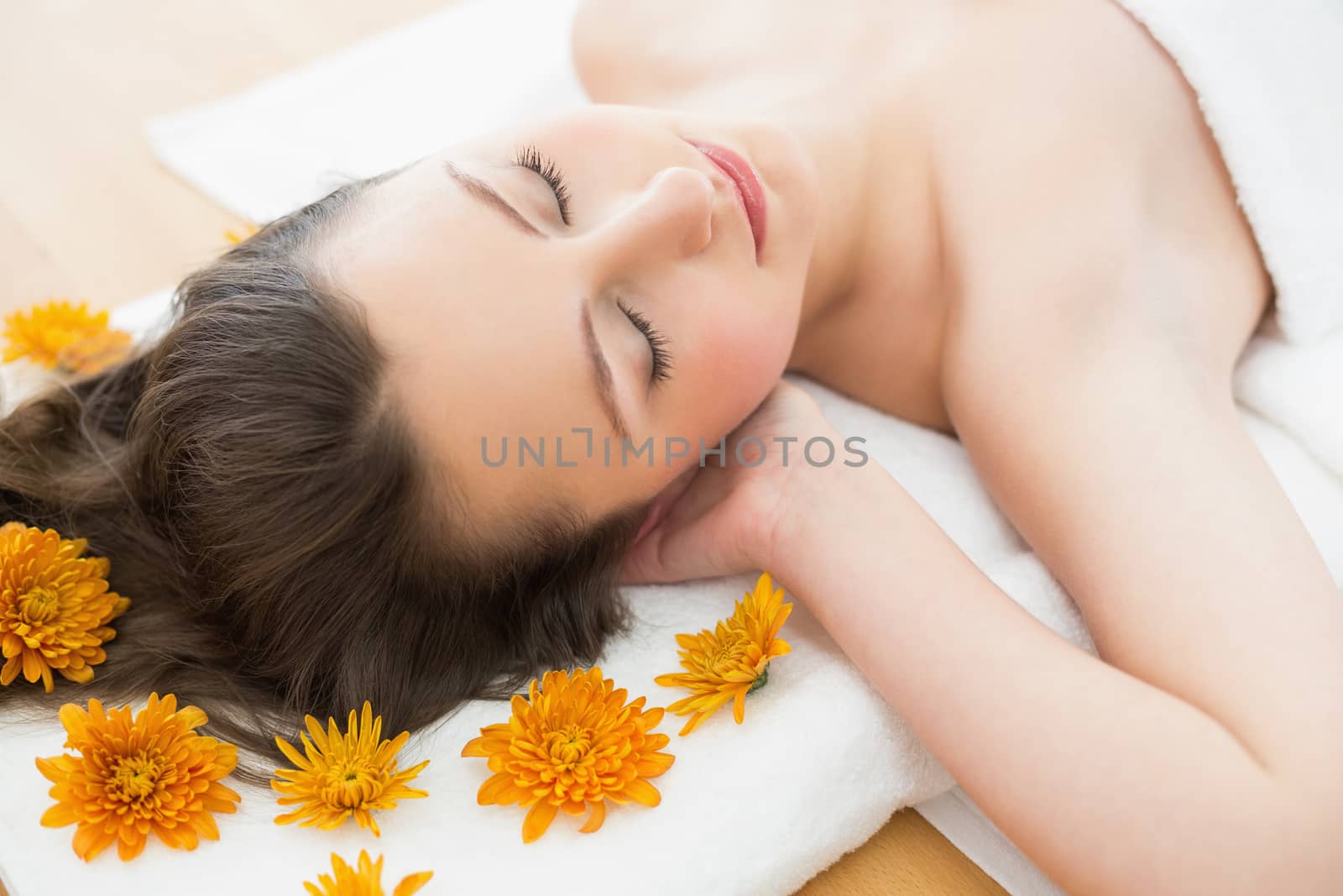 Overhead view of a young brunette lying on massage table in beauty salon