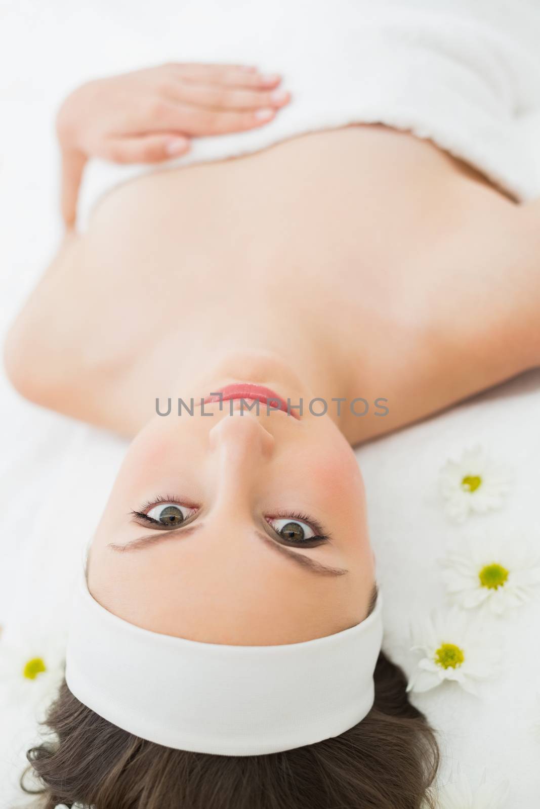 Overhead portrait of a young beautiful woman lying on massage table in beauty salon