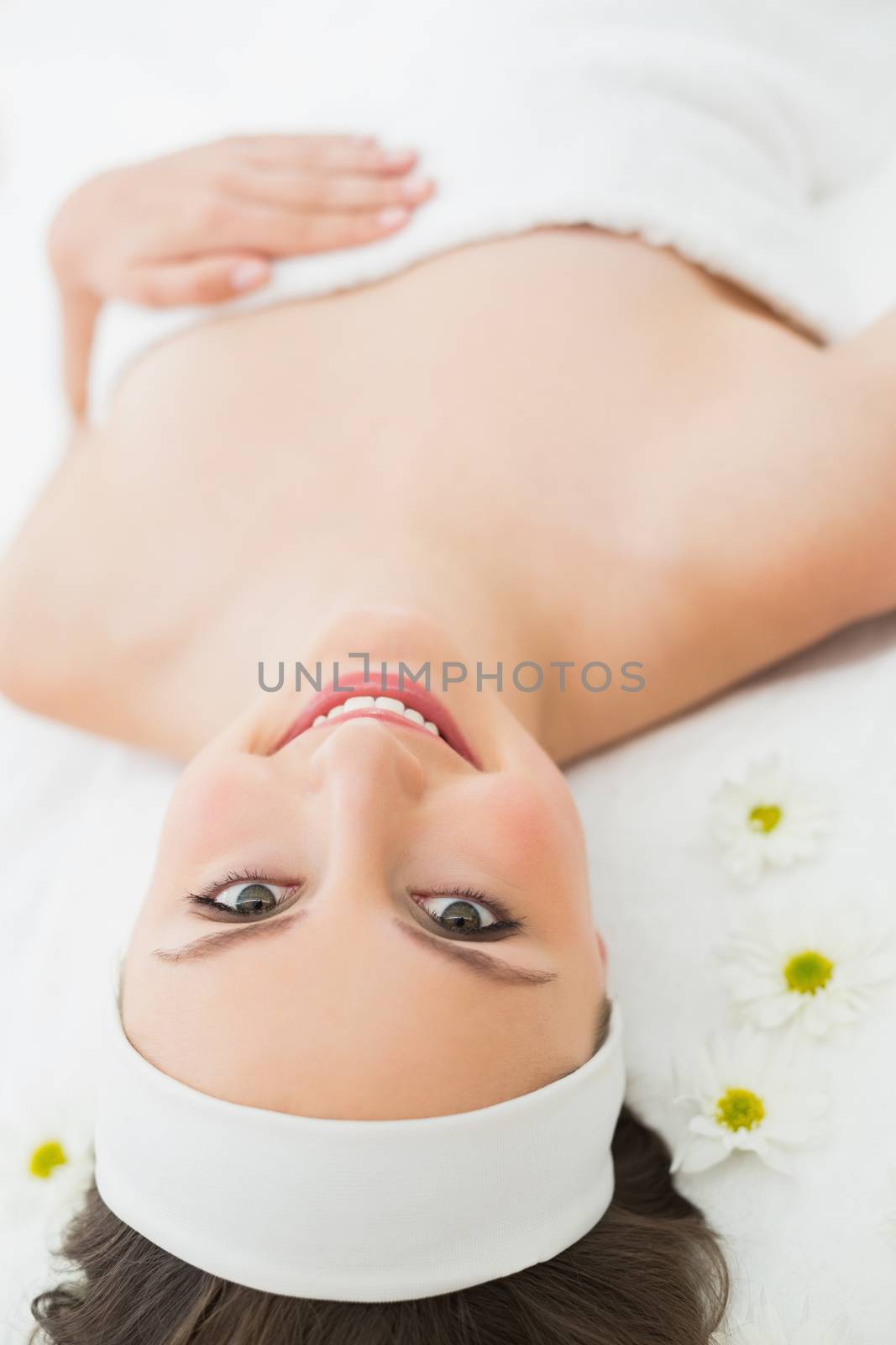 Overhead portrait of a young beautiful woman lying on massage table in beauty salon