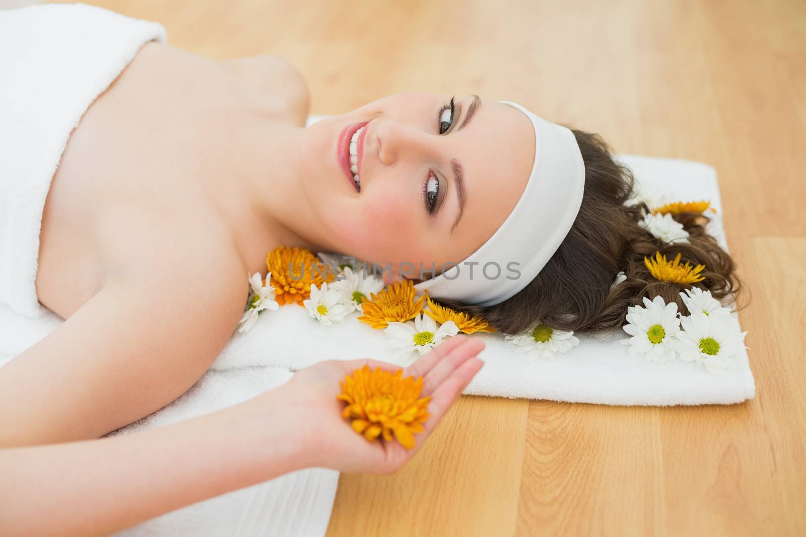 Side view portrait of a beautiful young woman with flowers in beauty salon
