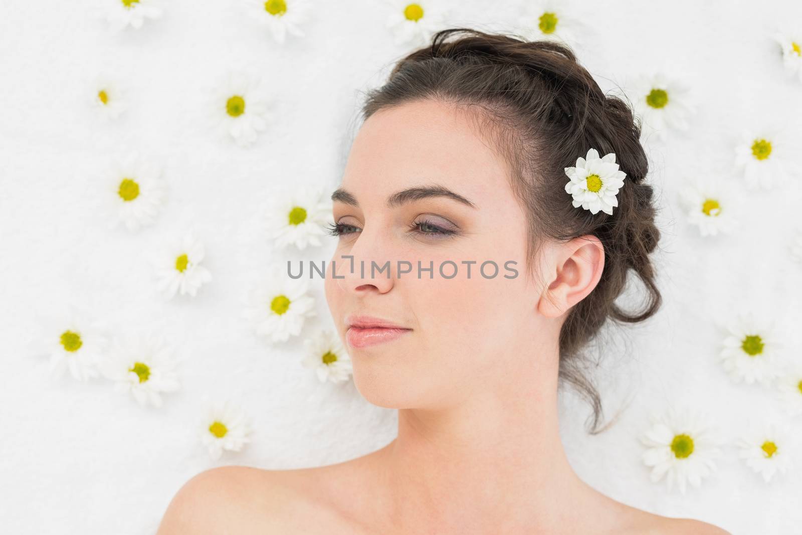 Close up of a beautiful young woman with flowers in beauty salon