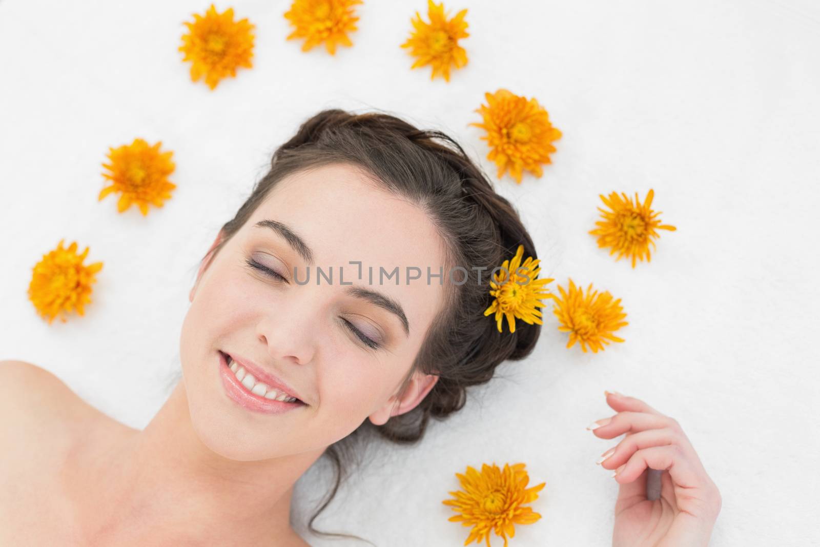 Close up of a beautiful young woman with flowers in beauty salon