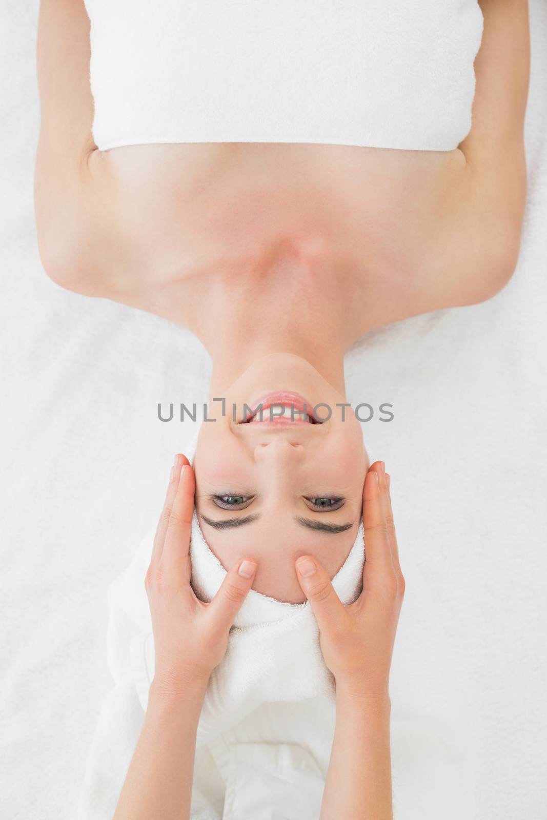 Close up of hands massaging a beautiful womans face at beauty spa