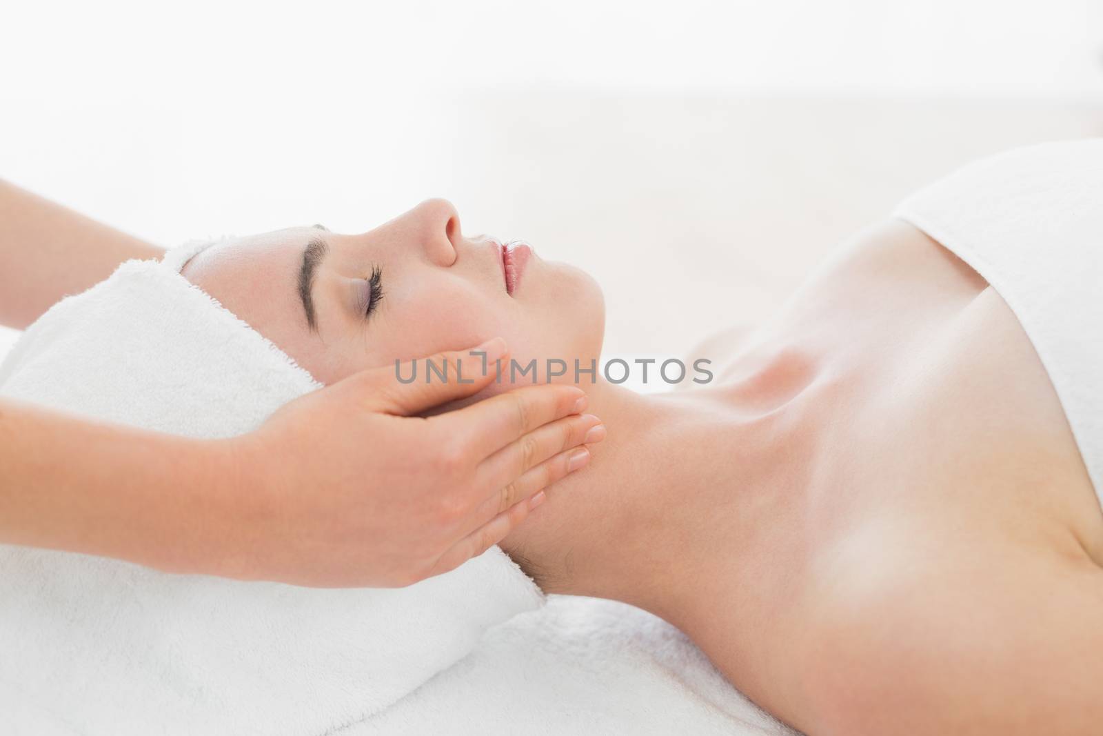 Hands massaging womans face at beauty spa by Wavebreakmedia