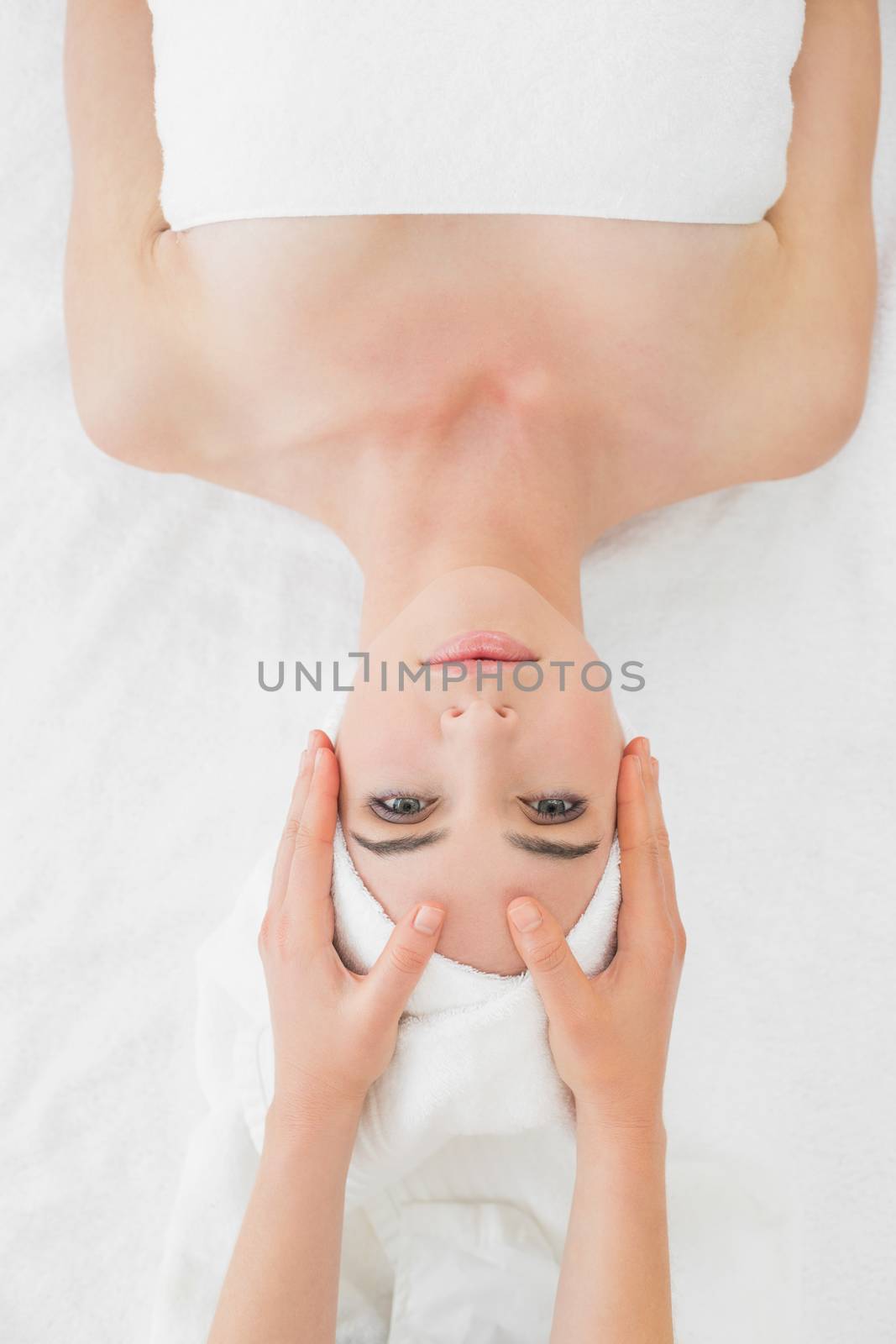 Close up of hands massaging a beautiful womans face at beauty spa