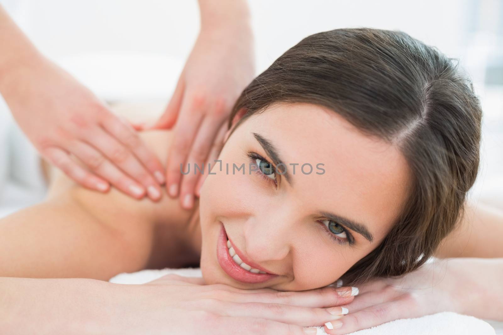 Smiling woman enjoying shoulder massage at beauty spa by Wavebreakmedia