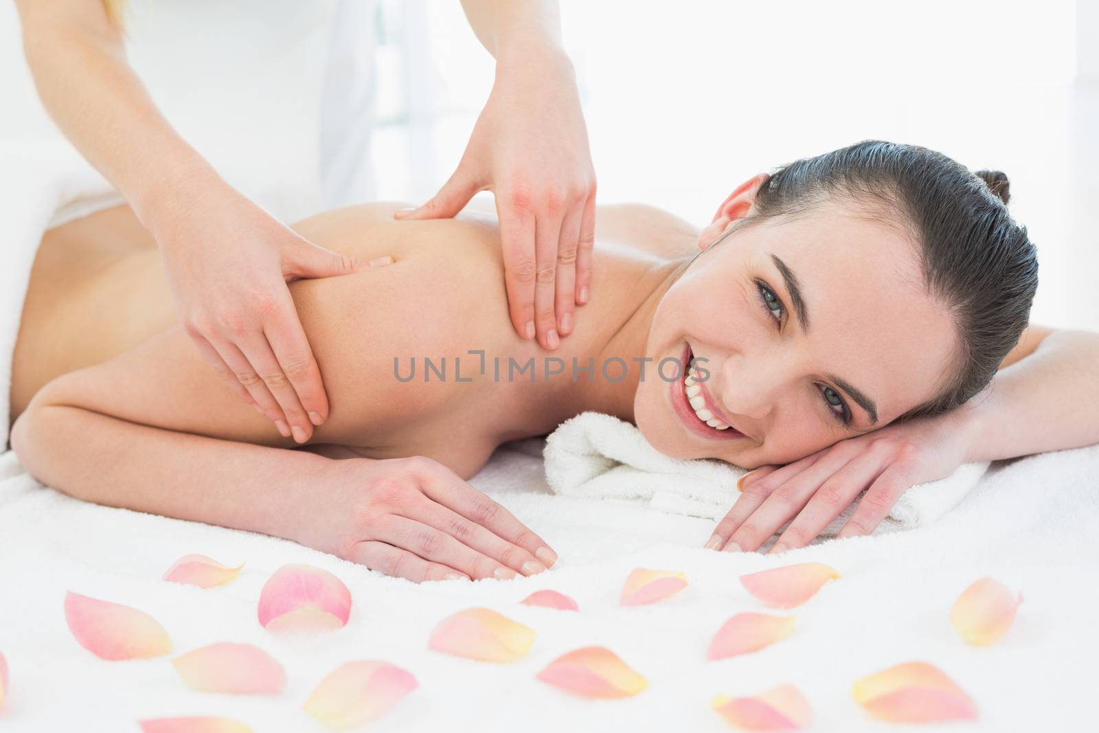 Close up of a beautiful woman enjoying shoulder massage at beauty spa