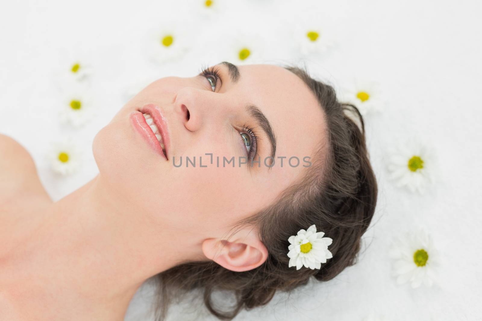 Close up of a beautiful young woman with flowers in beauty salon