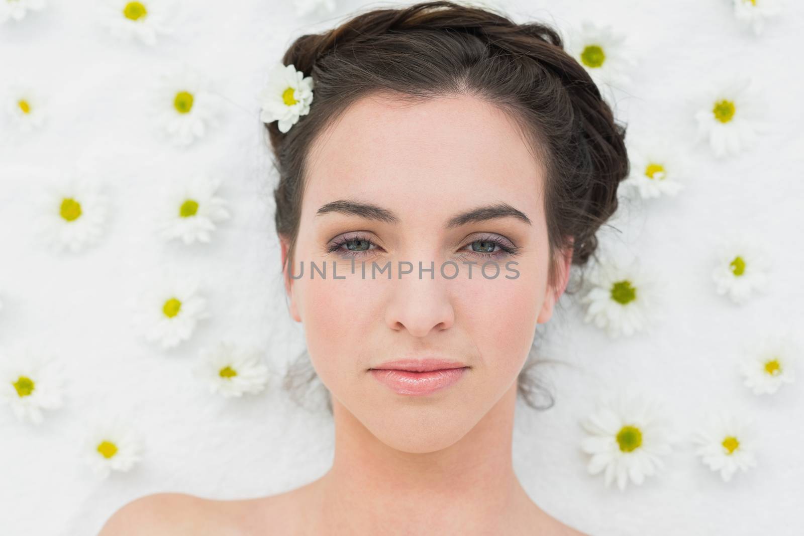 Overhead portrait of a beautiful young woman with flowers in beauty salon