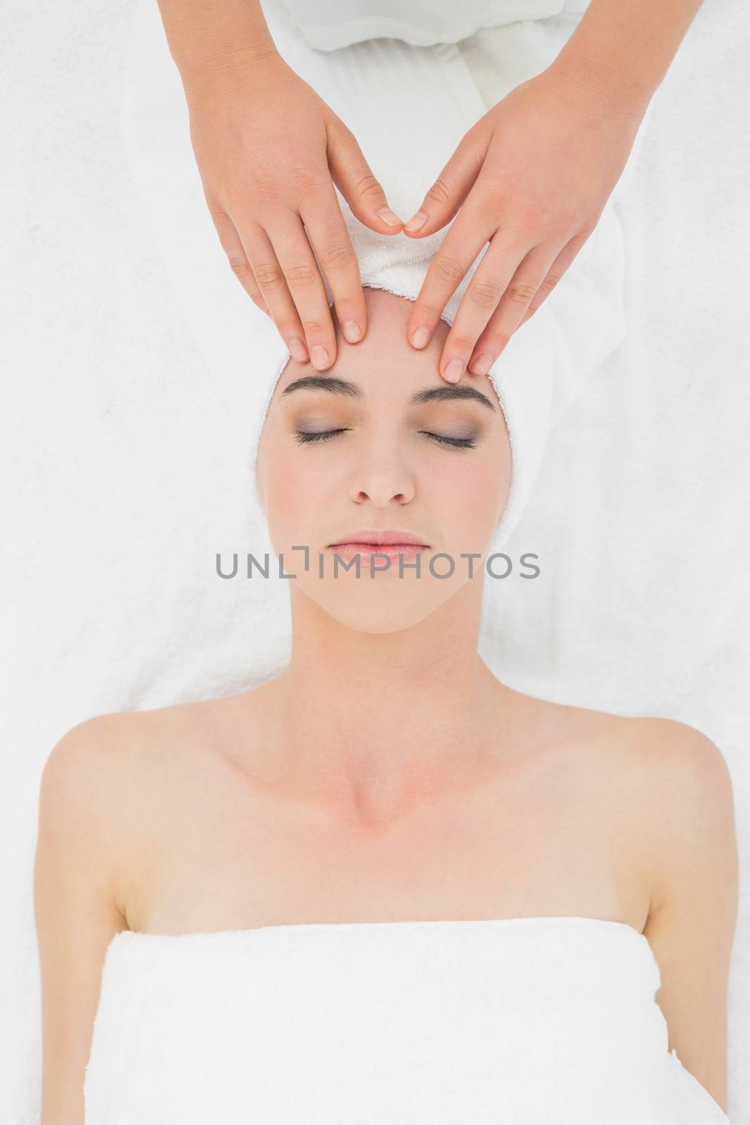 Hands massaging a beautiful womans forehead at beauty spa by Wavebreakmedia