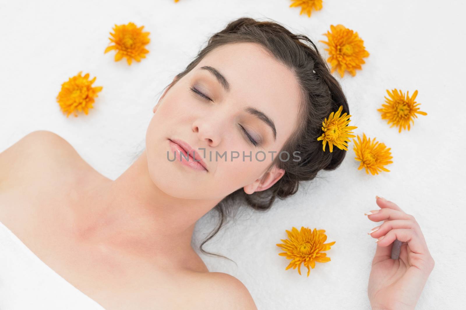 Close up of a beautiful young woman with flowers in beauty salon