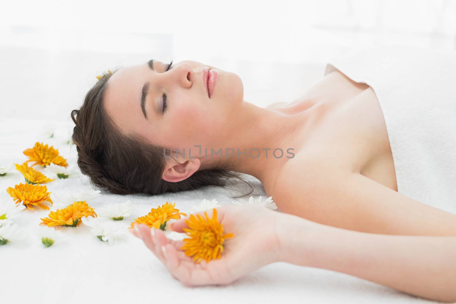 Close up of a beautiful young woman with flowers in beauty salon