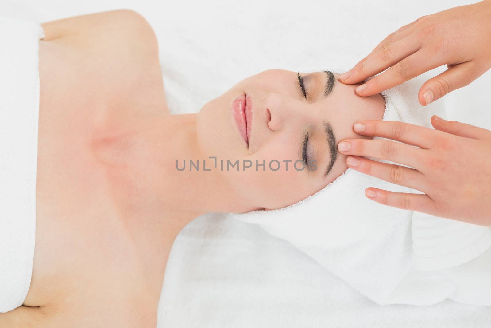 Hands massaging a beautiful womans forehead at beauty spa by Wavebreakmedia