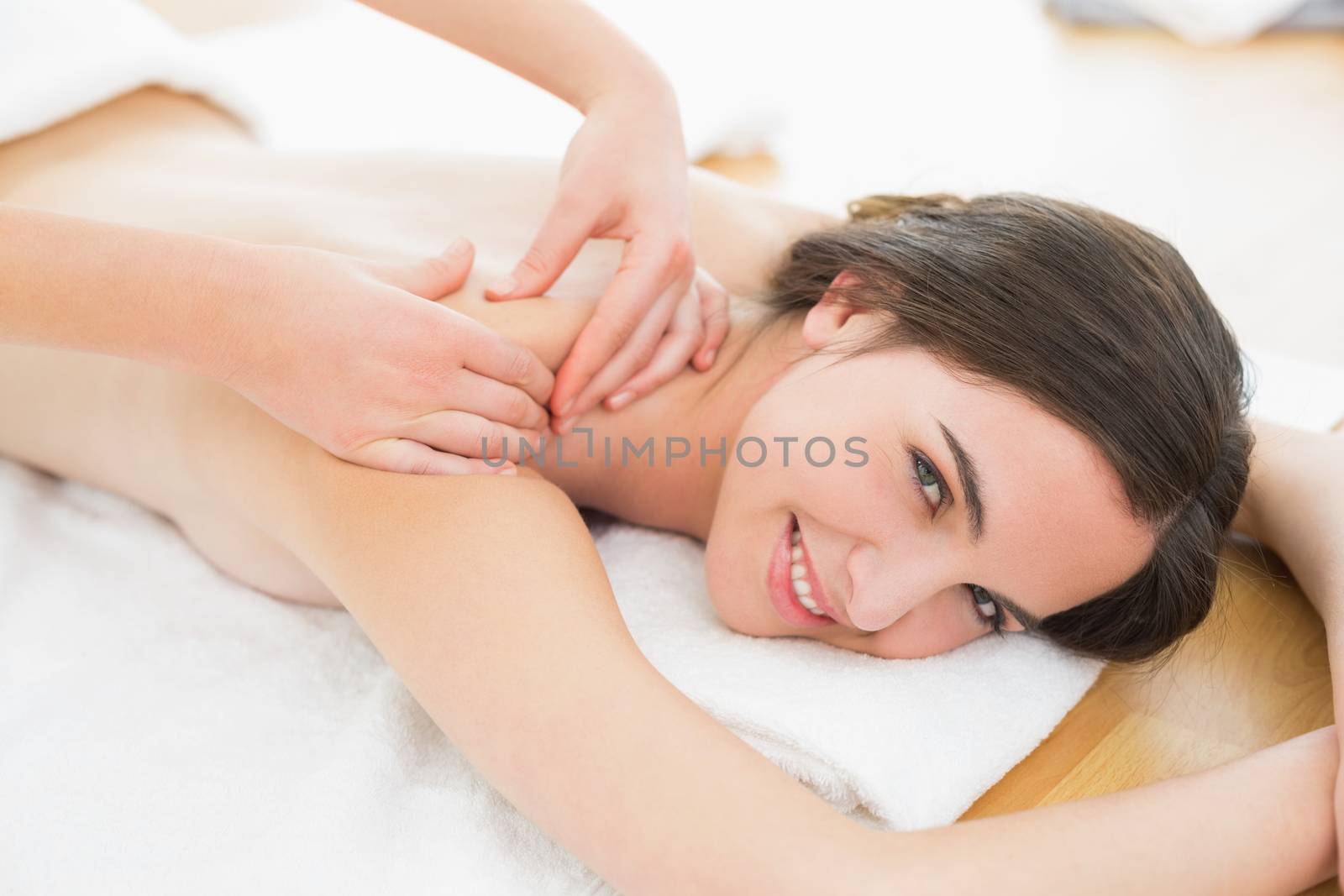 Smiling beautiful woman enjoying shoulder massage at beauty spa by Wavebreakmedia